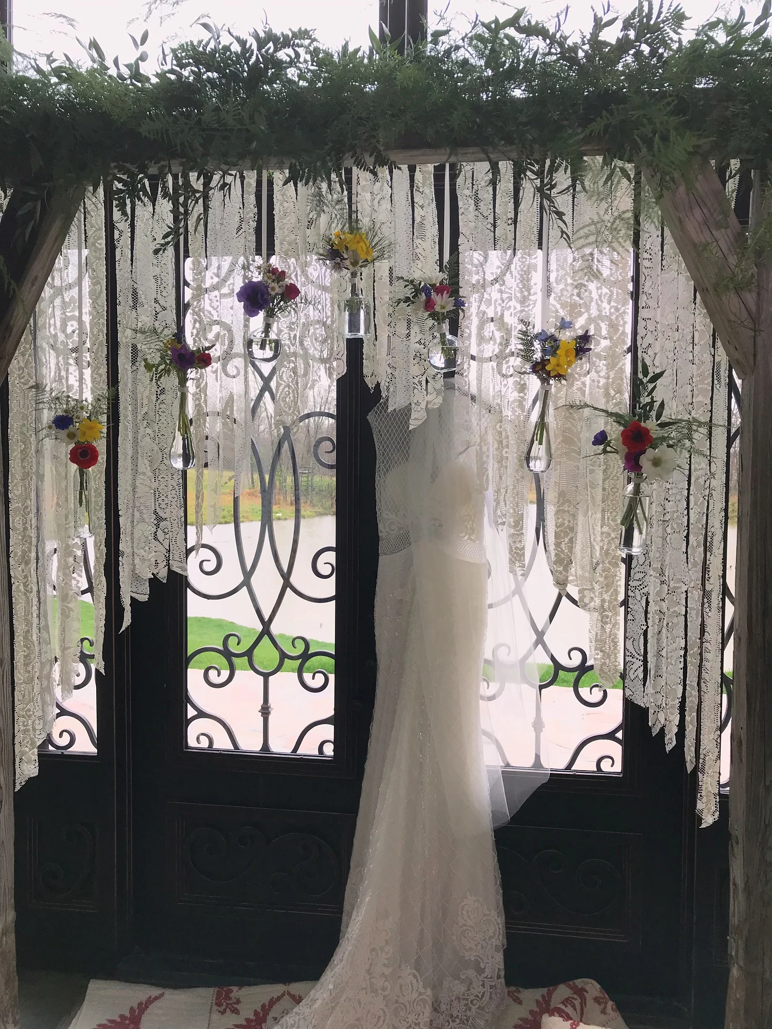 Meagan’s arbor—lace strips and hanging bottles with tiny bouquets