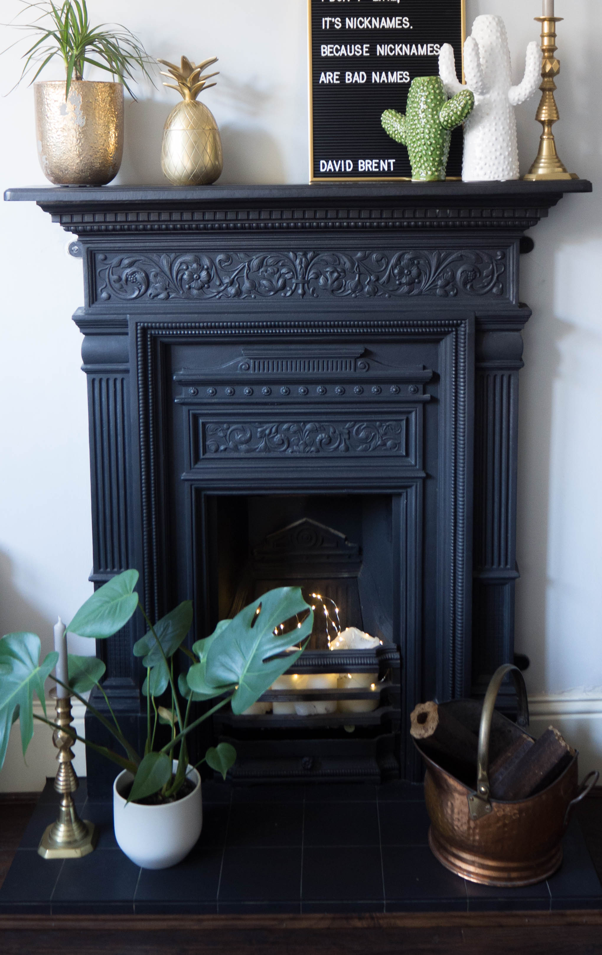 My cast iron fireplace surround with ceramic cactus vases, brass pineapple and a letter board.