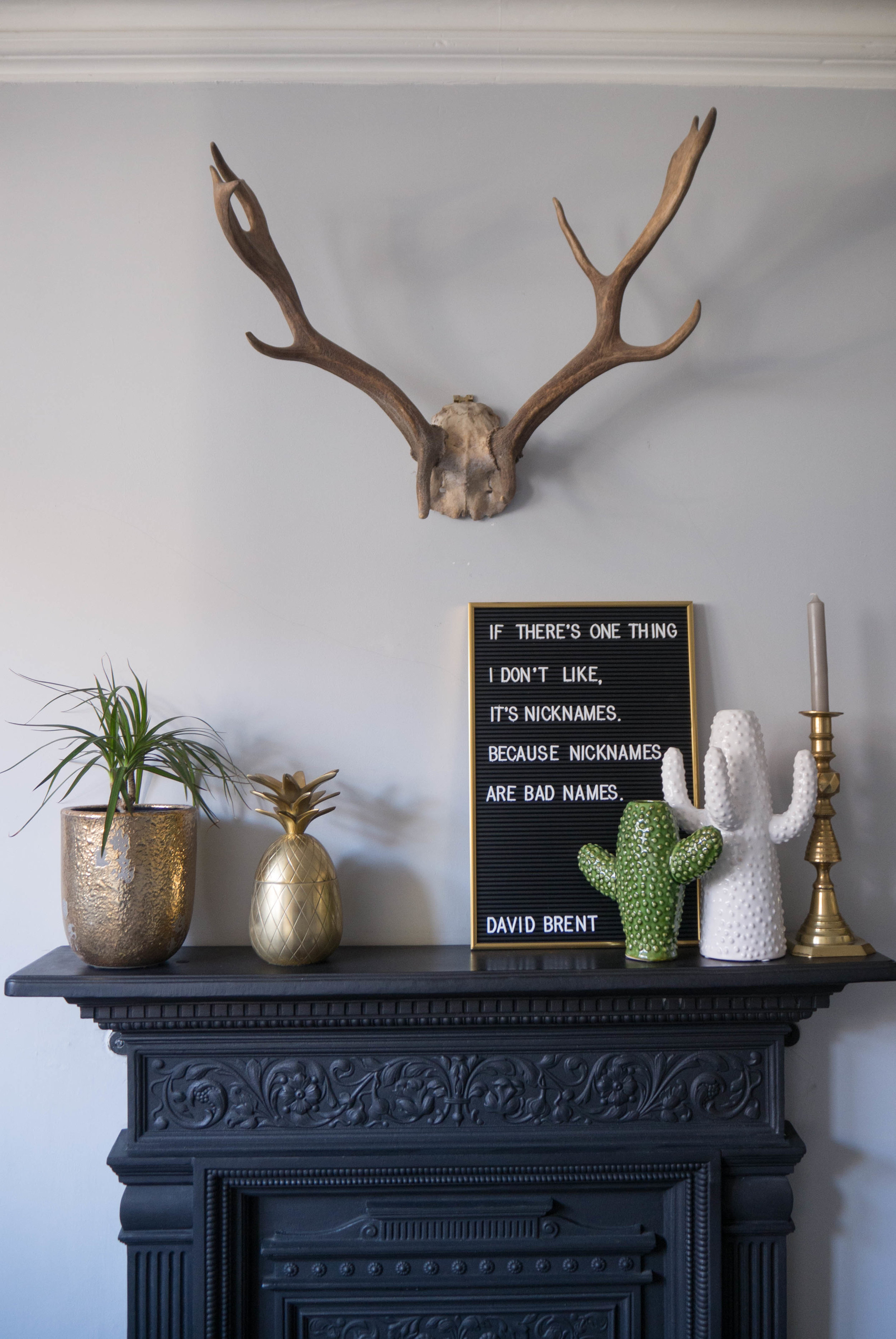 My cast iron fireplace surround with ceramic cactus vases, brass pineapple and a letter board.
