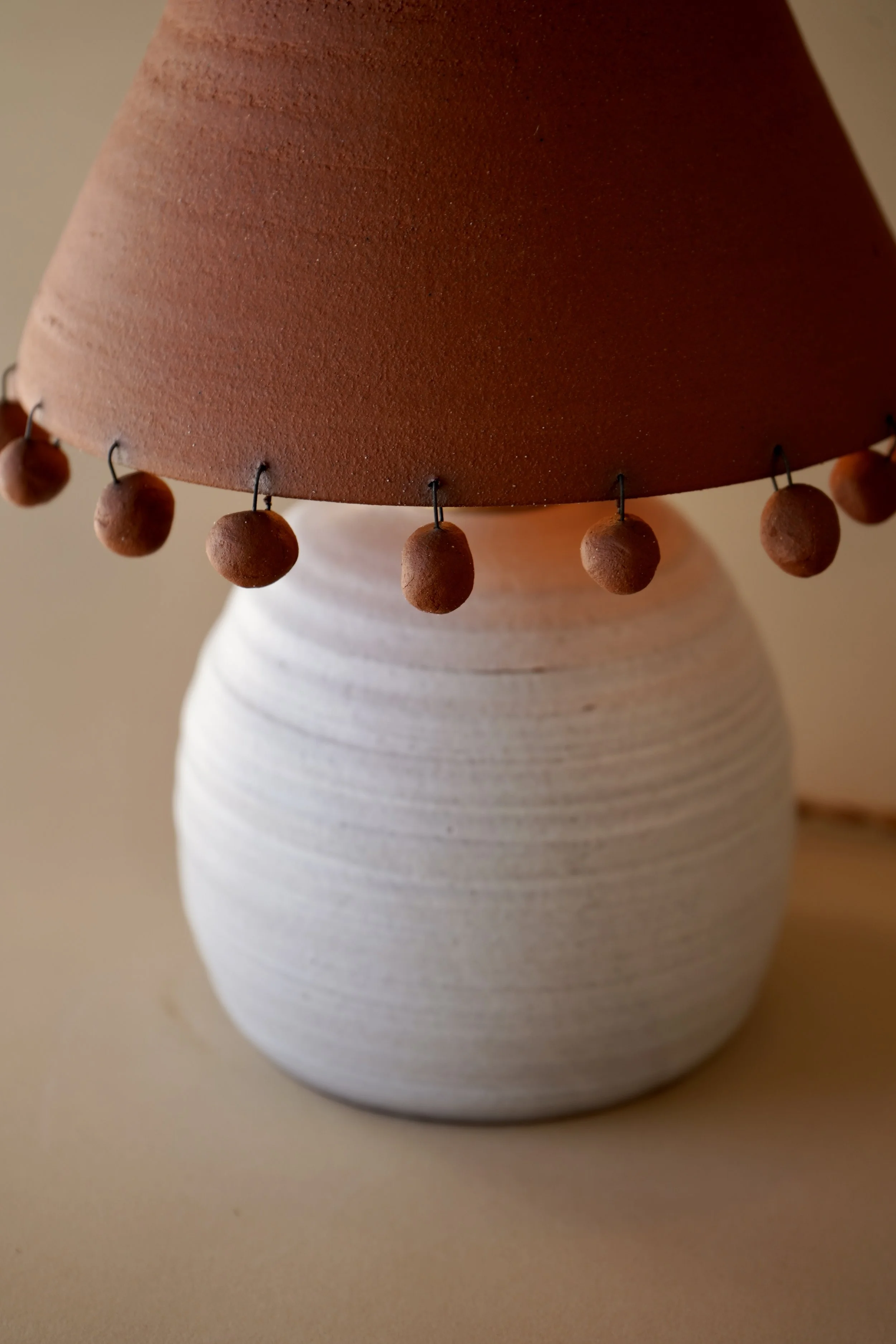 Handmade two-tone ceramic table lamp with white stoneware base, terracotta shade, and hand-rolled ceramic beads