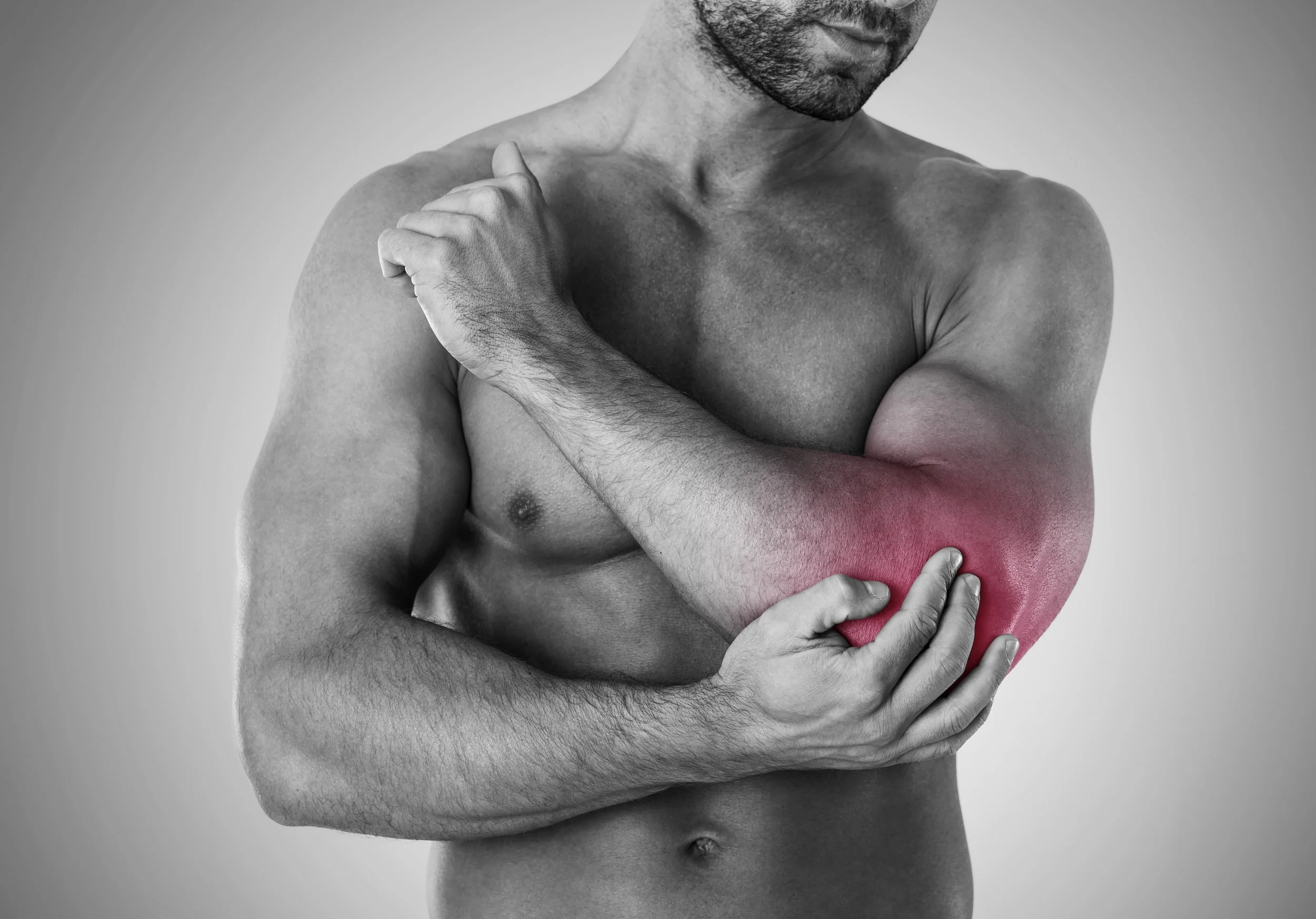 Padel player holding the outside of the elbow in pain after a backhand