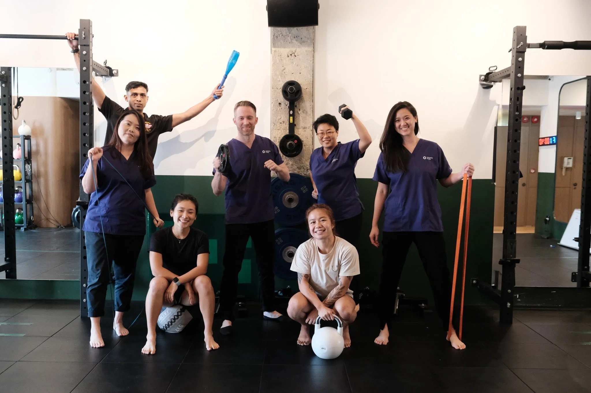 Sports concussion program team posing with fitness equipment.