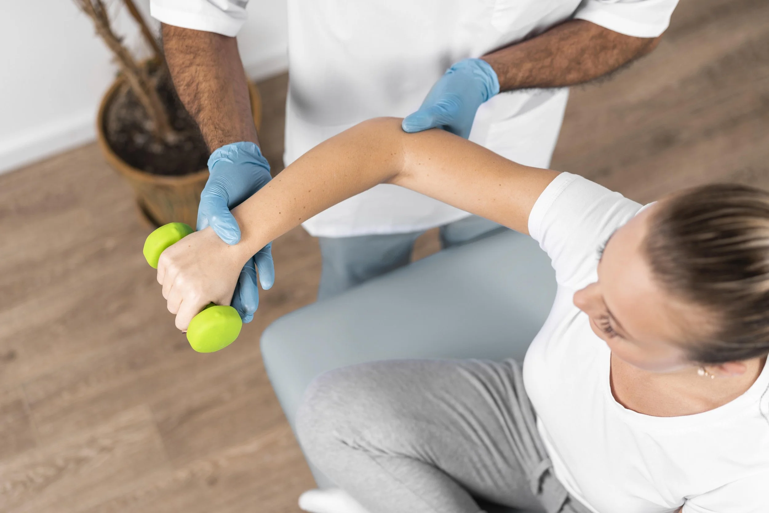 Physiotherapist assessing a padel player's elbow during a consultation