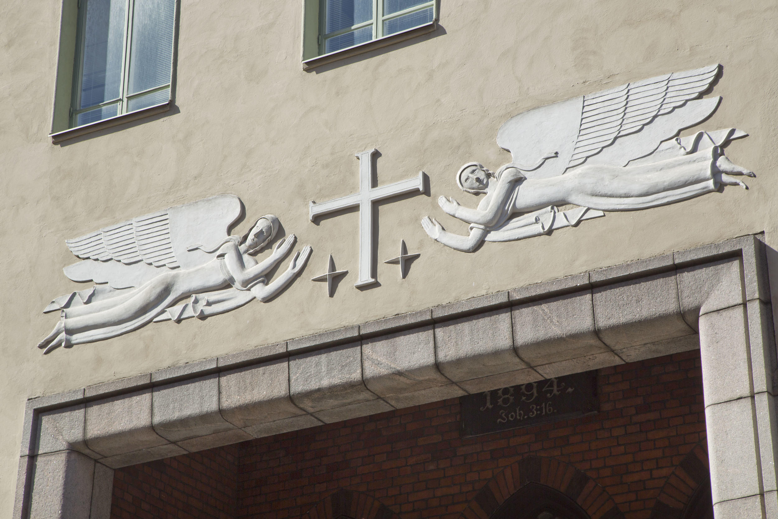 Kuvassa Gunnar Finnen taiteilemat enkelireliefit Luther-kirkon sisäänkäynnin yläpuolella. Kuva: Olli Häkämies.