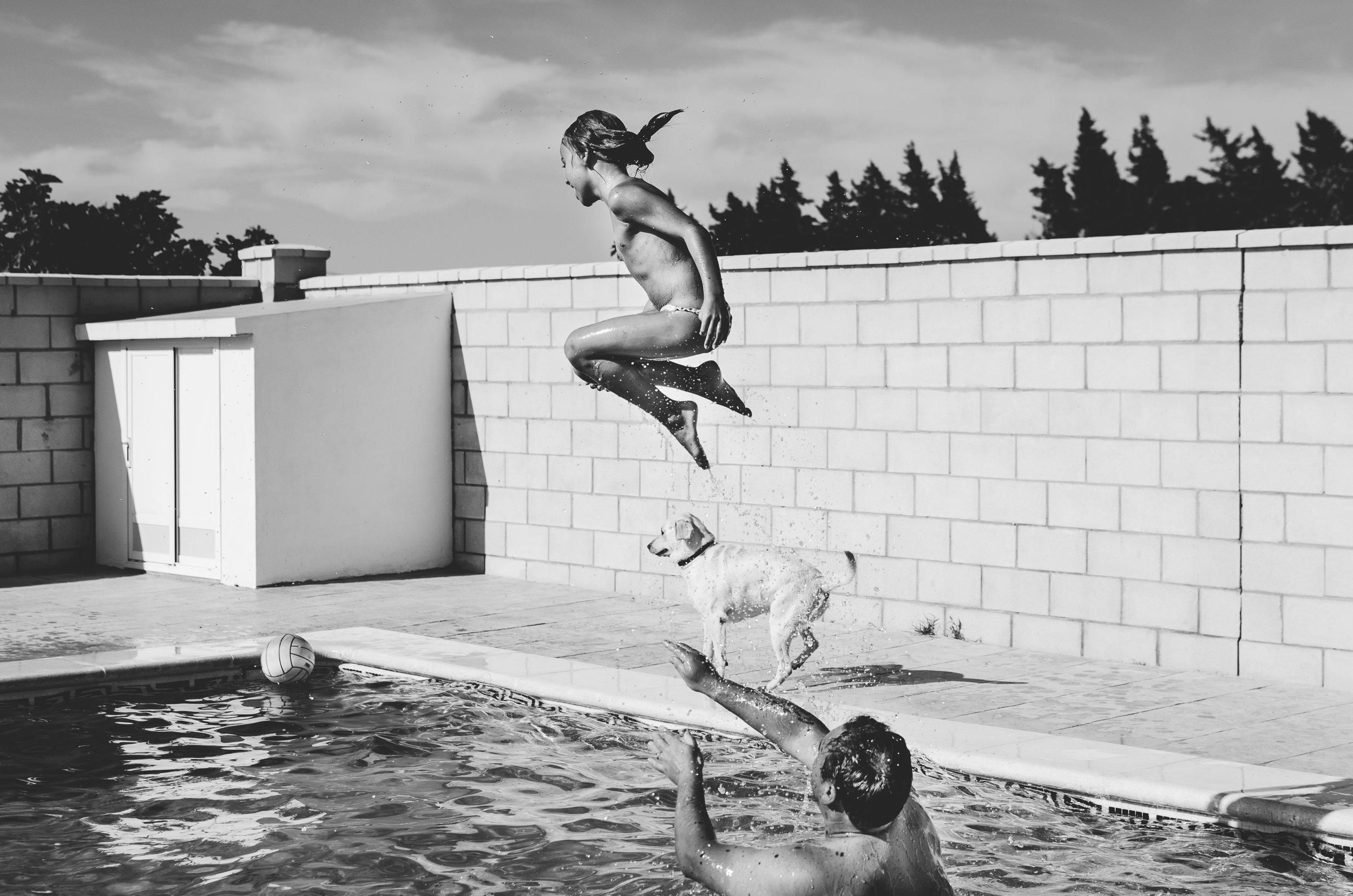 Girl jumping in the swimming pool in summer