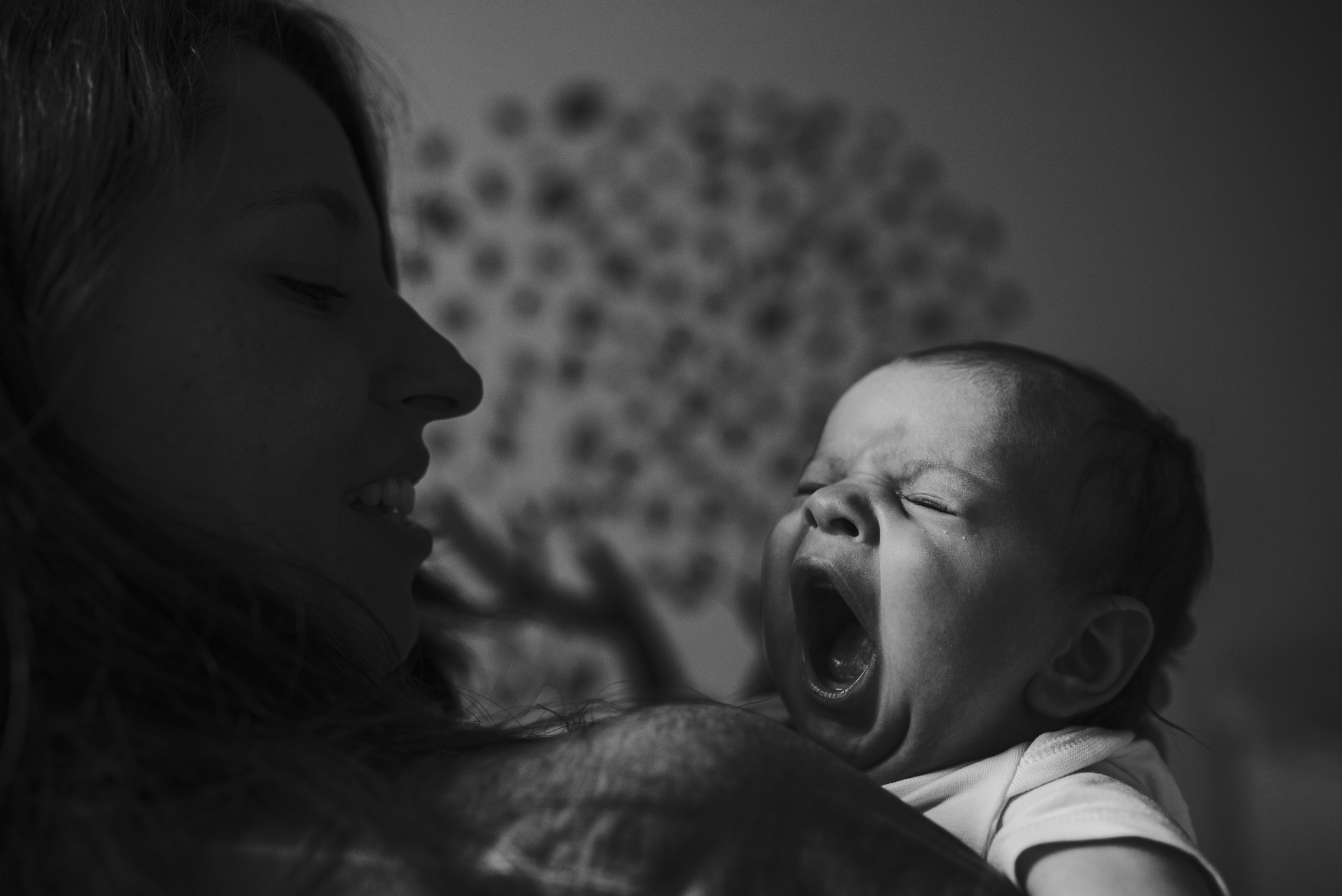 Newborn baby yawing in mom's arms.jpg