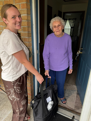 Hannah handing an Outreach bag to a Jefferson County resident