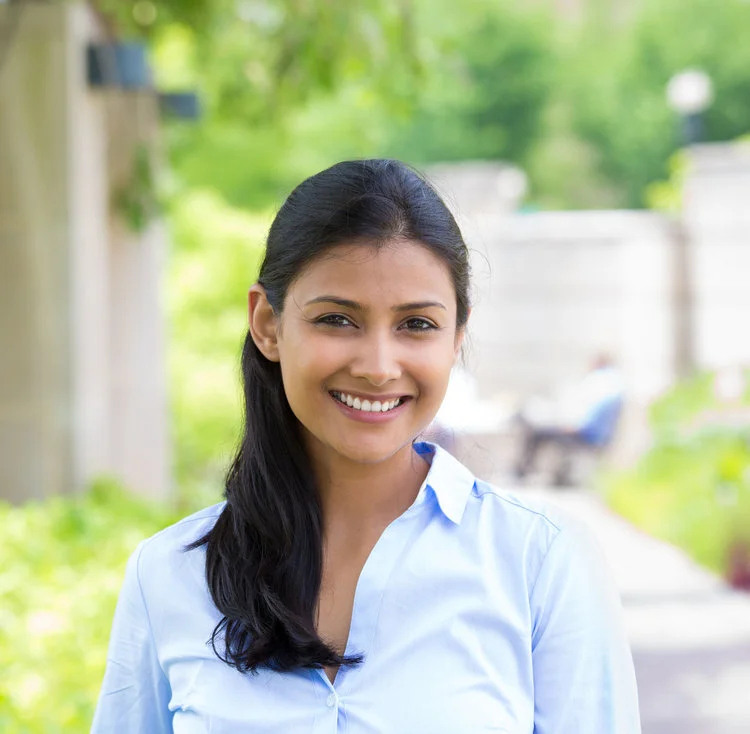 31275509 - closeup headshot portrait, young beautiful business woman in blue shirt smiling isolated on nature background with trees. positive human emotion facial expression