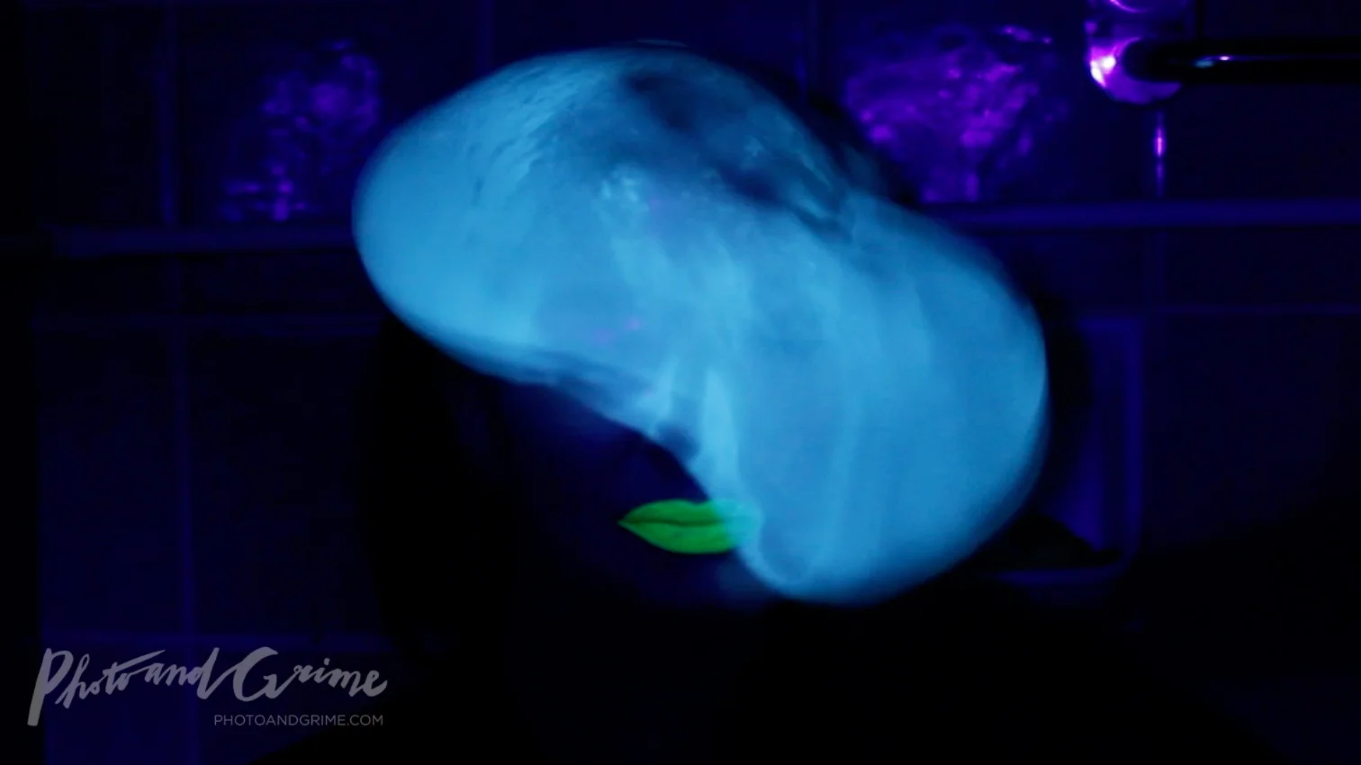 A Tonic-filled condom in blacklight (ultraviolet light).