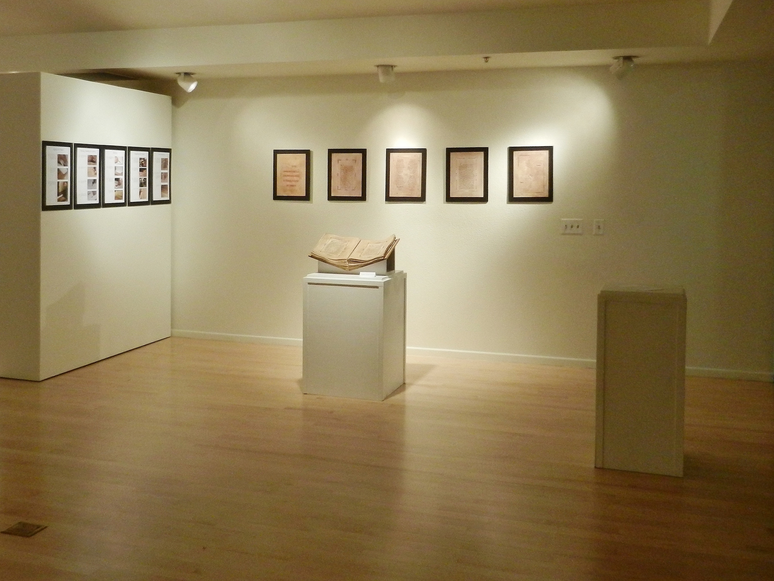  Friesen Galleries,&nbsp; A Song of Glory , 2012. The pages mounted beside the manuscript depict the creative process that went into this project; the pages mounted behind are scans of folios throughout the book (provided as viewers were not permitte