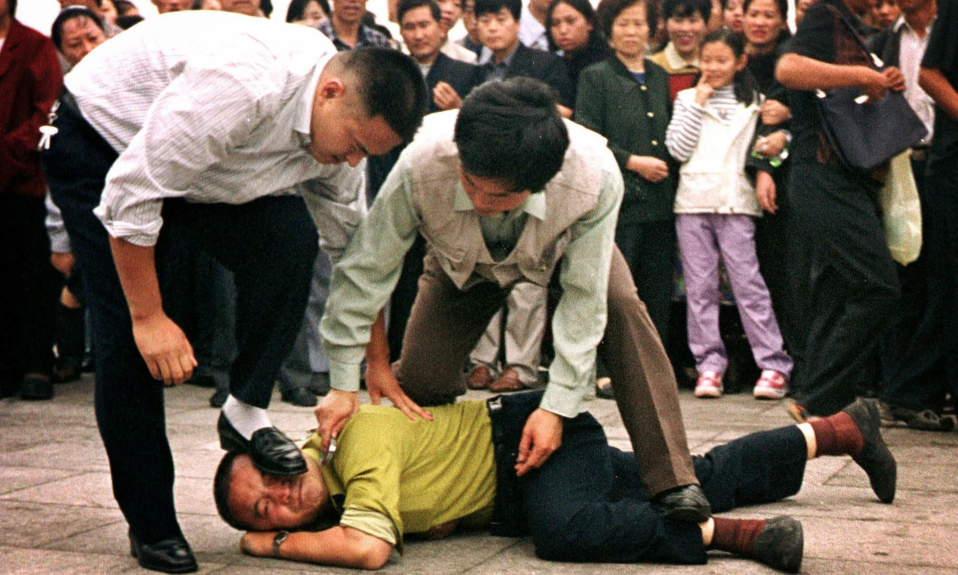  Police detain a Falun Gong protester in Tiananmen Square as a crowd watches in Beijing, in 2000. Photograph: Chien-Min Chung/AP