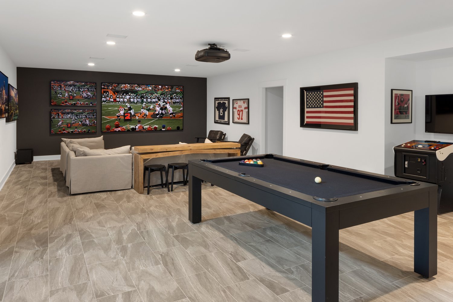 Luxurious home theater and recreation room with pool table, plush seating, and framed sports memorabilia.
