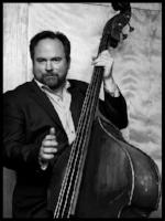Joe Kyle Jr. was fortunate enough to have been drafted into musical service during the Great Swing Wars of early-1990s San Francisco, when entry-level gigs were plentiful and vintage clothes in his size were still available. His musical education began in the trenches and the barrooms and dance halls of the Greater Bay Area, and continues to this day. Joe has become an in-demand performer and session player known throughout the land for his superb feel, musical agility, adaptability and propensity for slap bass and tragicomic asides. He might be the only bassist to have played with pianists Martin Denny, Al Kooper, AND Pinetop Perkins, although not with all on the same session, sadly. Joe can frequently be seen and heard performing and recording with many Bay Area groups, including Michael Zisman's Americano Social Club , HowellDevine , Mitch Polzak's Royal Deuces , Koolerator , The Cottontails , and The Waybacks .