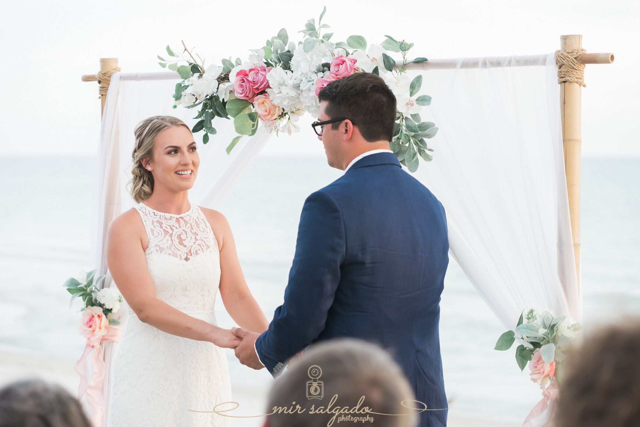wedding-ceremony-holding-hands, beach-wedding-ceremony, beach-venue, bride-dress, groom-suit