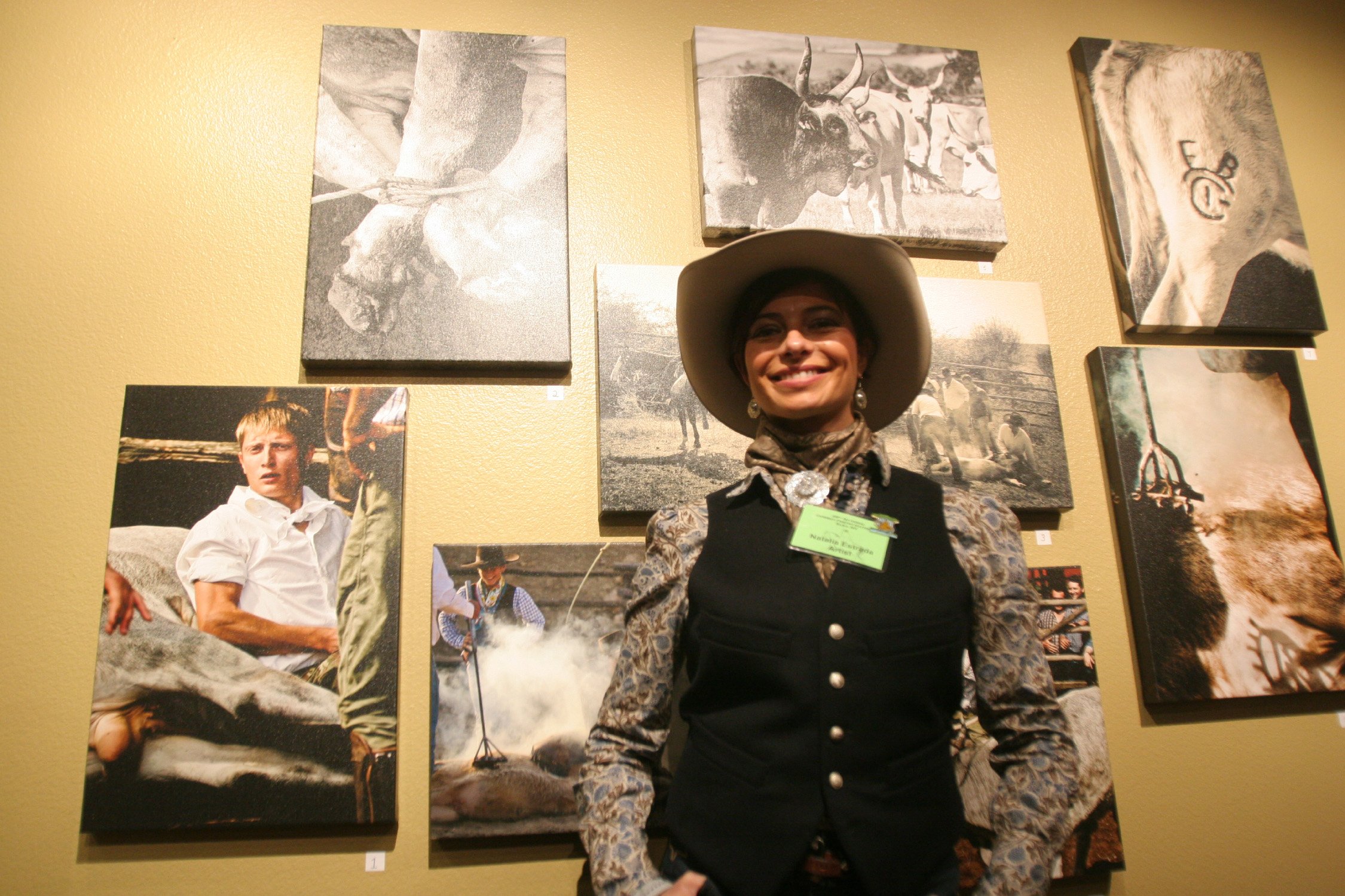 Italian special guest Natalia Estrada stands in front of Wiegand Gallery's "Italian Buckaroos: Old World &amp; New World" exhibit at the 29th Gathering. Photo by Charlie Ekburg.