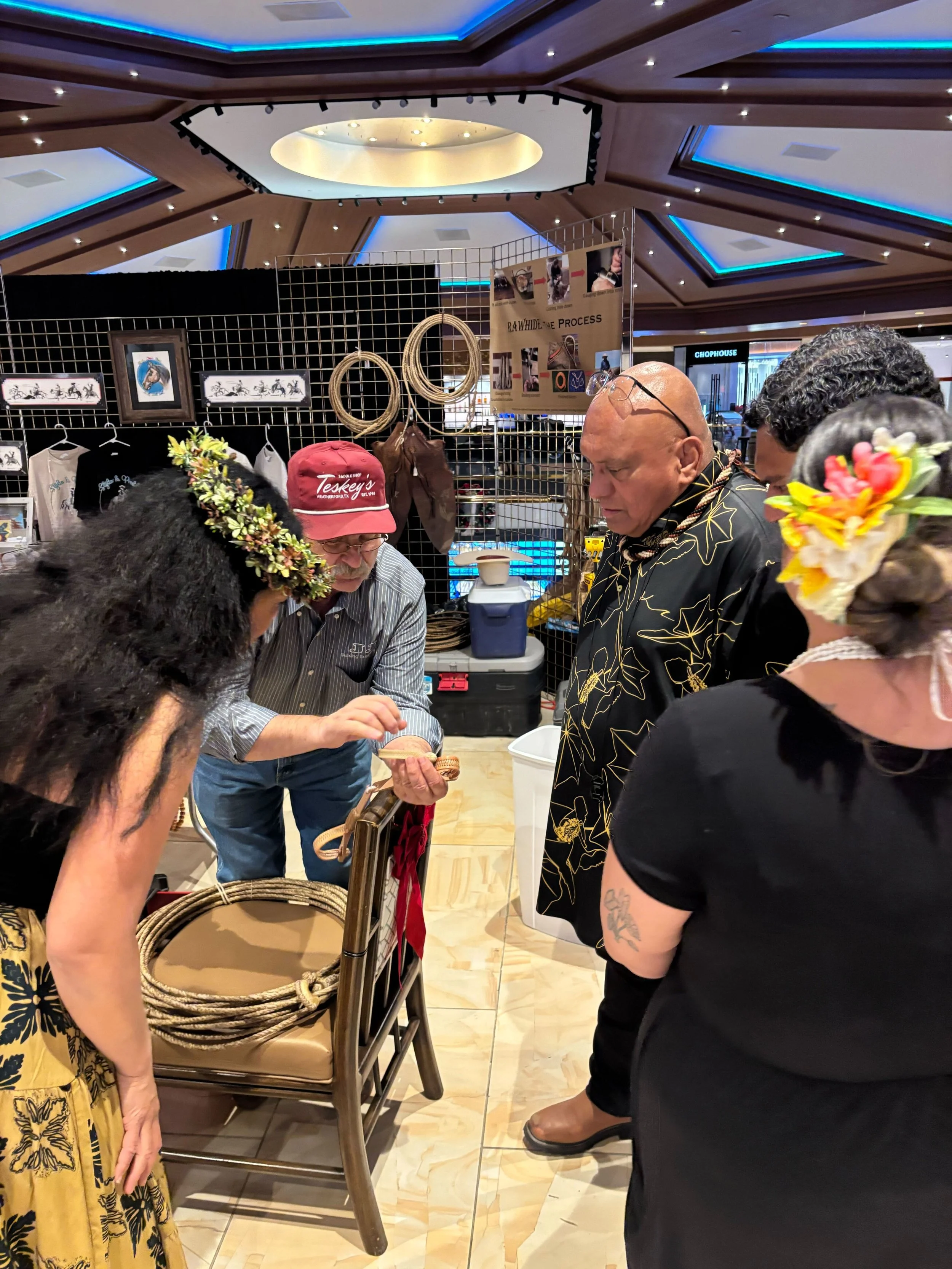 Rawhide braider Randy Roberts gives a demonstration to Gary Haleamau &amp; Kāwili