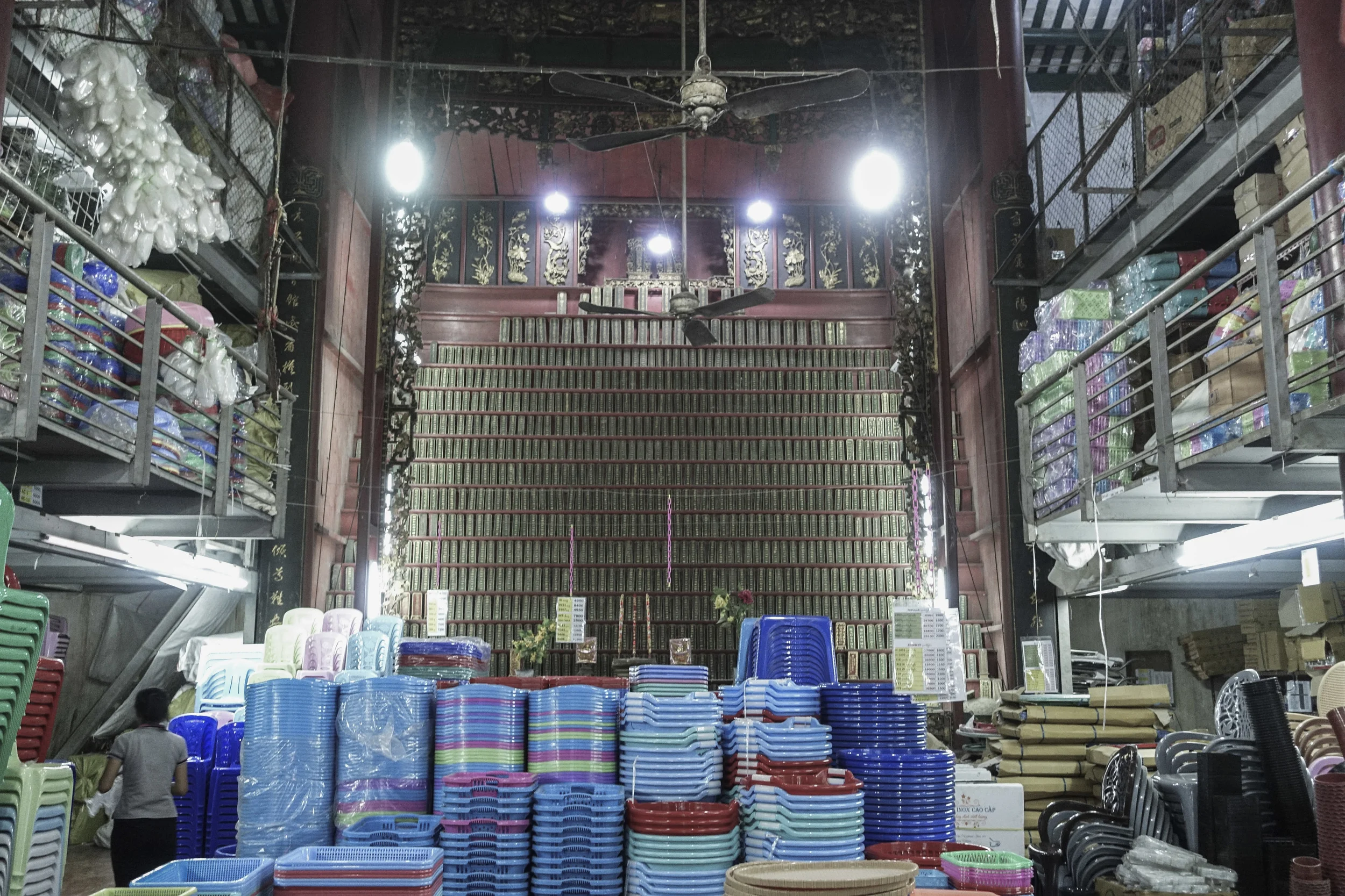 A 'donation' wall for blessings sits at the back of a plastic goods warehouse.