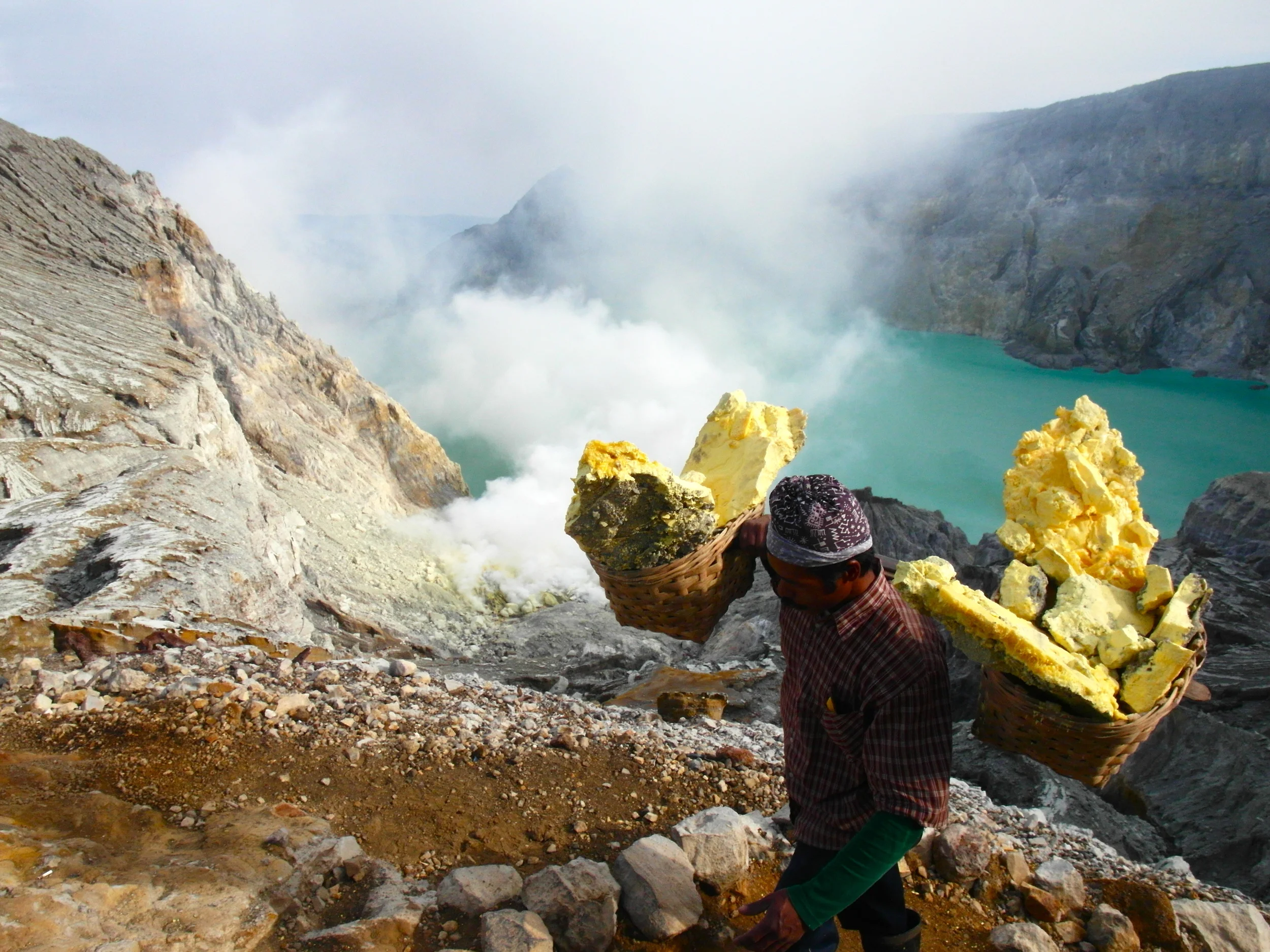 One of the many miners carrying his freshly-laden load down the volcano.