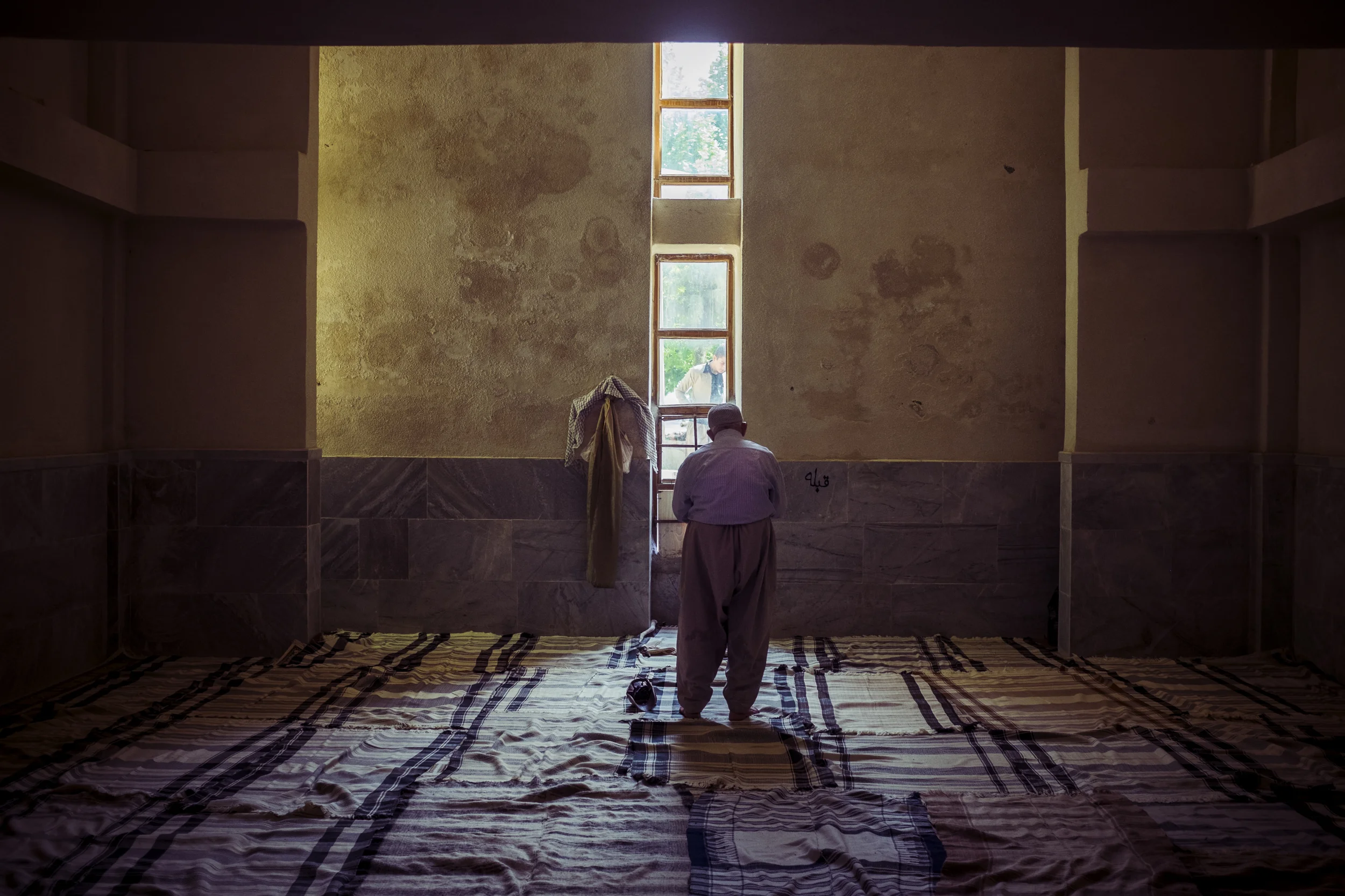 An aged man praying in the mosque near the Zrebar lake in Mariwan.