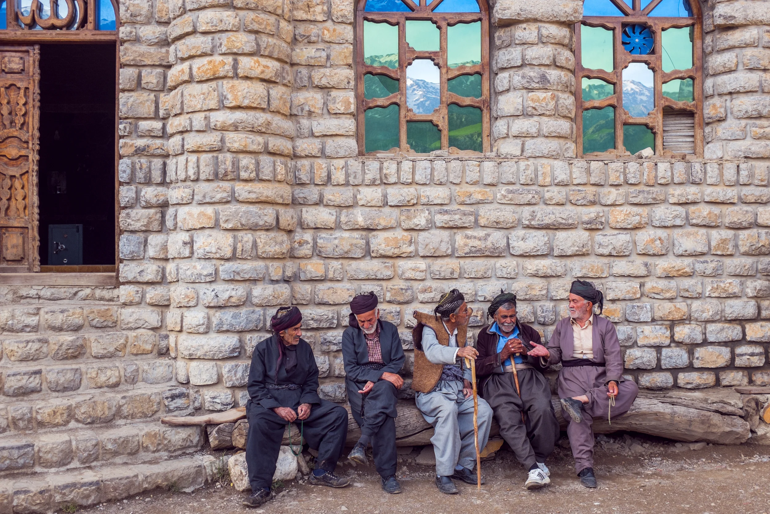 Men, dressed in the traditional Kurdish wear, waiting for the prayer call outside the mosque in Hawraman Takhte. 