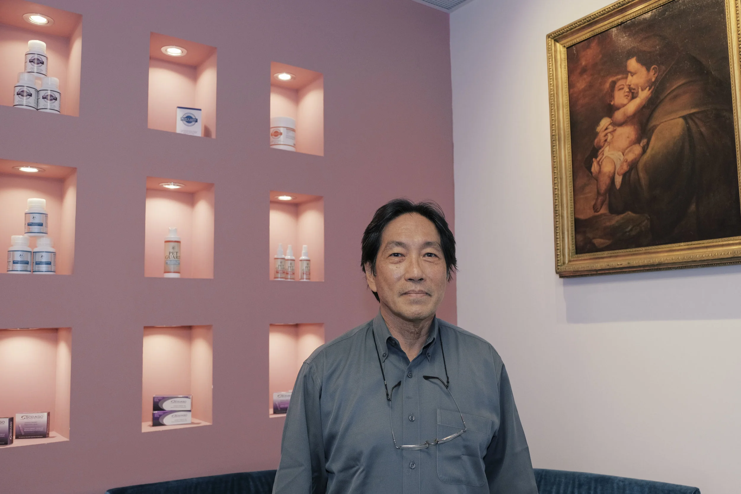 Ly stands in his ARC Health Services office by a painting of St Anthony Abbot that he had purchased, if he remembers correctly, more than 20 years ago in Paris. "It wasn't only St Francis of Assisi who loved the animals," he explains. Photo: Marc Nair