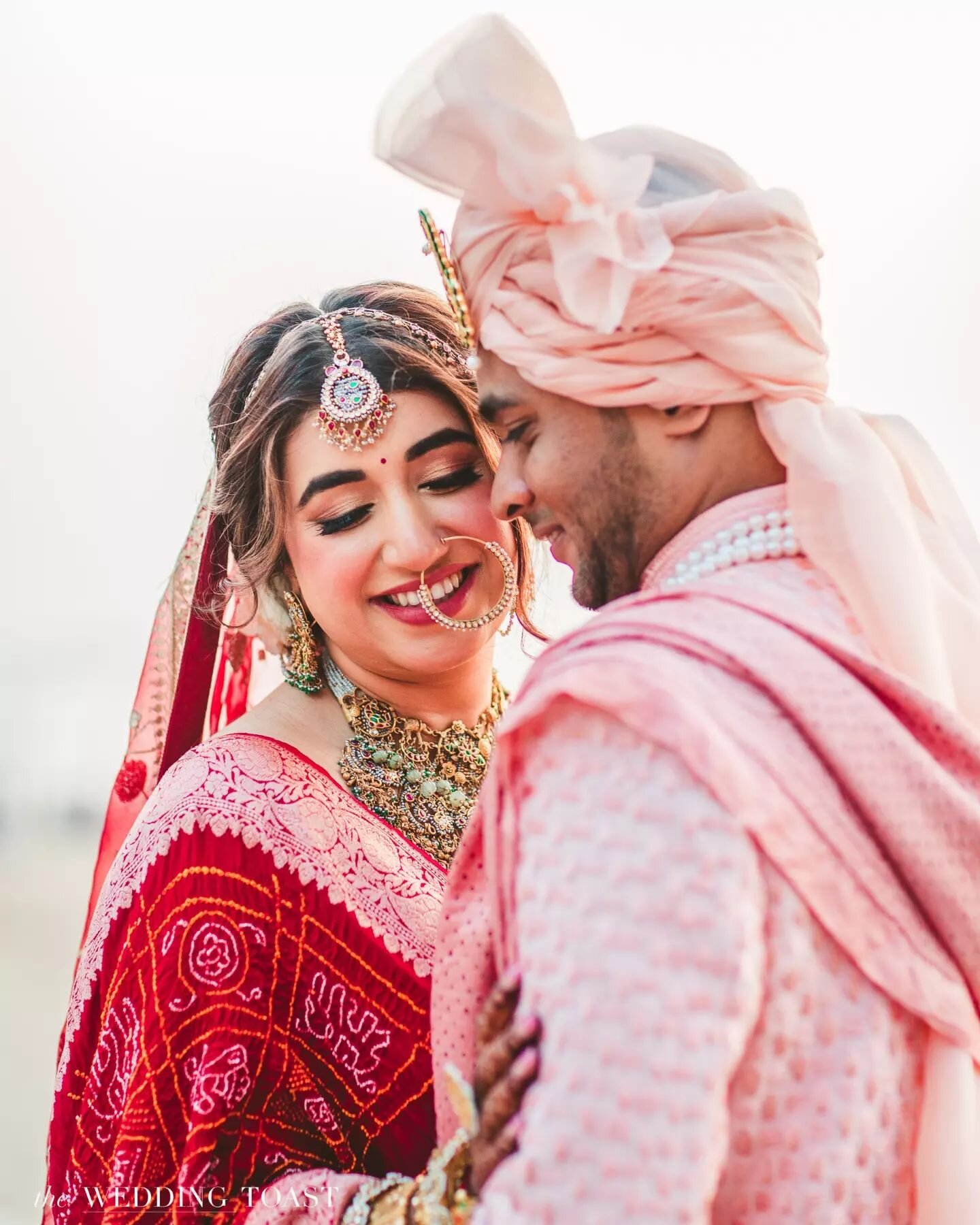On the mumbai beach stood Lekhinee a vision in her flowy red bridal lehenga, swaying with every ocean breeze. 

And by her side, the dapper groom, Sourabh, looking absolutely regal in his off-white sherwani, adorned with a soft pink dupatta and turba