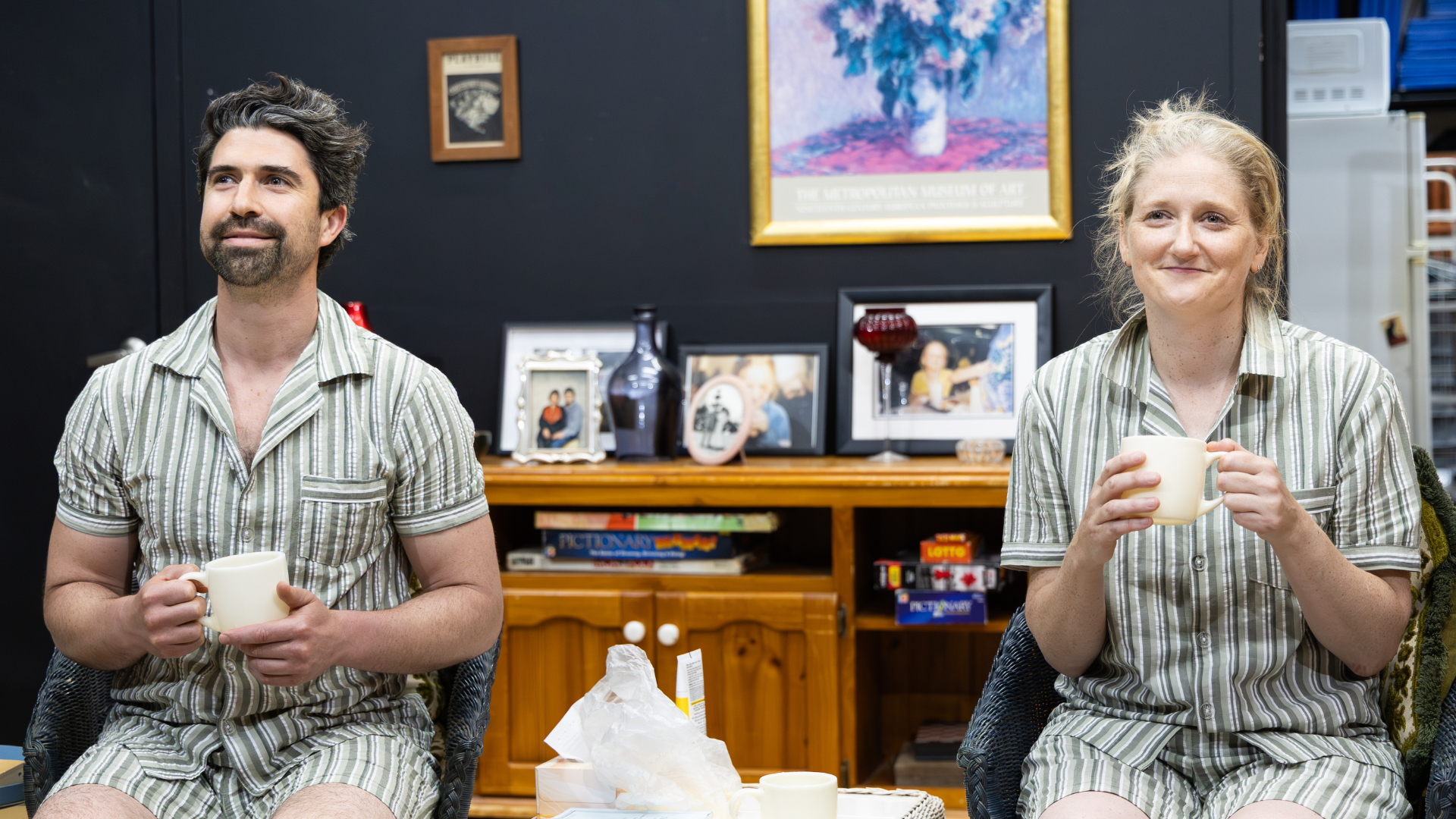 Two actors seated in matching striped pyjamas during a Howard Fine Acting Studio Masterclass scene study performance, holding mugs in a naturalistic domestic set