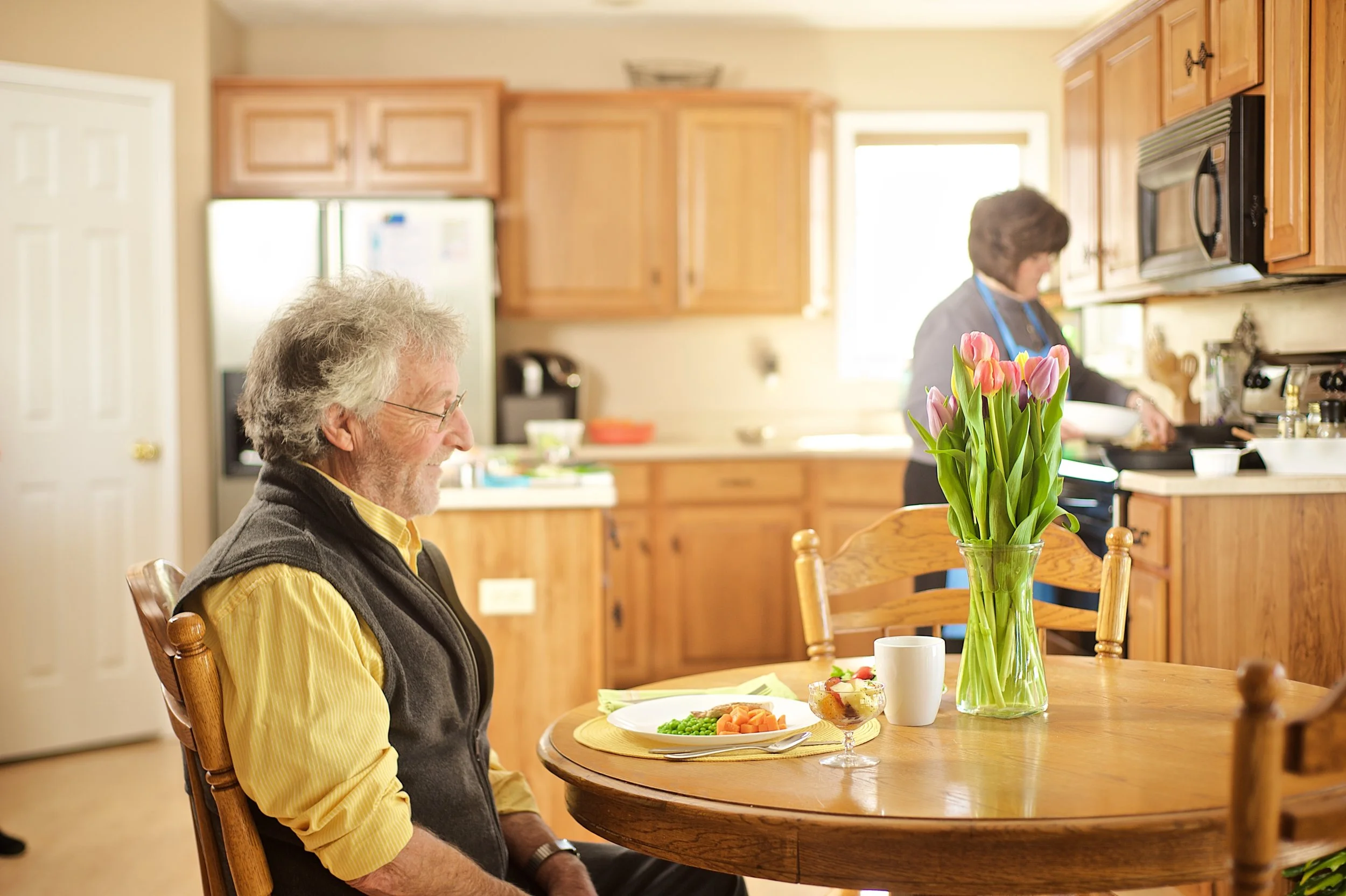 Elder with blurred caregiver in back.jpg