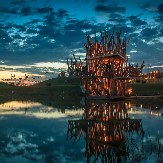 'The Temple' Art Installation for Secret Garden Party 2013. This project was the first studioTAC project - where the design and build of ATC met the curation of TCA. It was a 3 story structure built in 8 days over a shallow man-made lake. Accessed by a pier , beautifully made by Eddy Lewellyn, the structure housed a metal chandelier which traversed up through the 3 floors to the top. Guests were invited to reflect on this calm space, light a lantern and hang it from the chandelier which in turn lit the space. by studioTAC Design, build and care of the space by Secret Arts / studioTAC Photography by Nick Caro