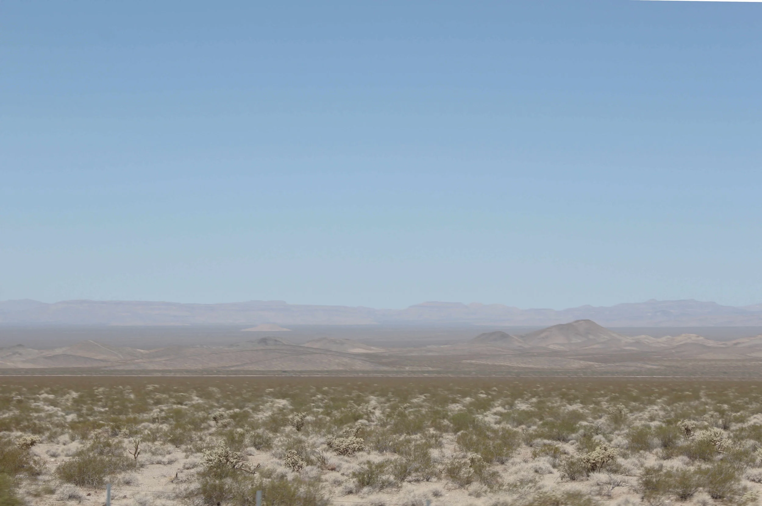 Haze that sits atop a landscape dotted with Yucca and Prickly Pear.