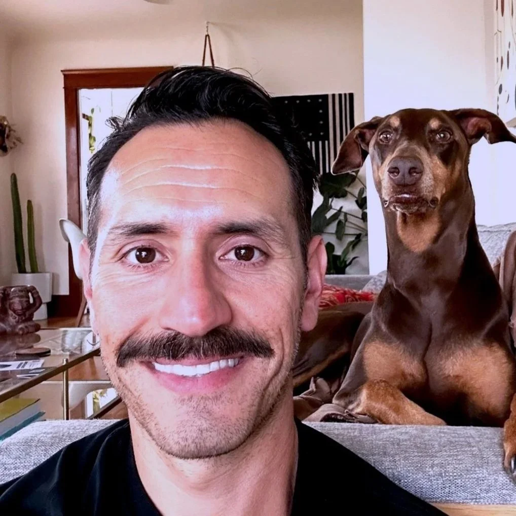 Dr Daniel Cordero Chiropractor in San Diego, and his office helper Bean the doberman.