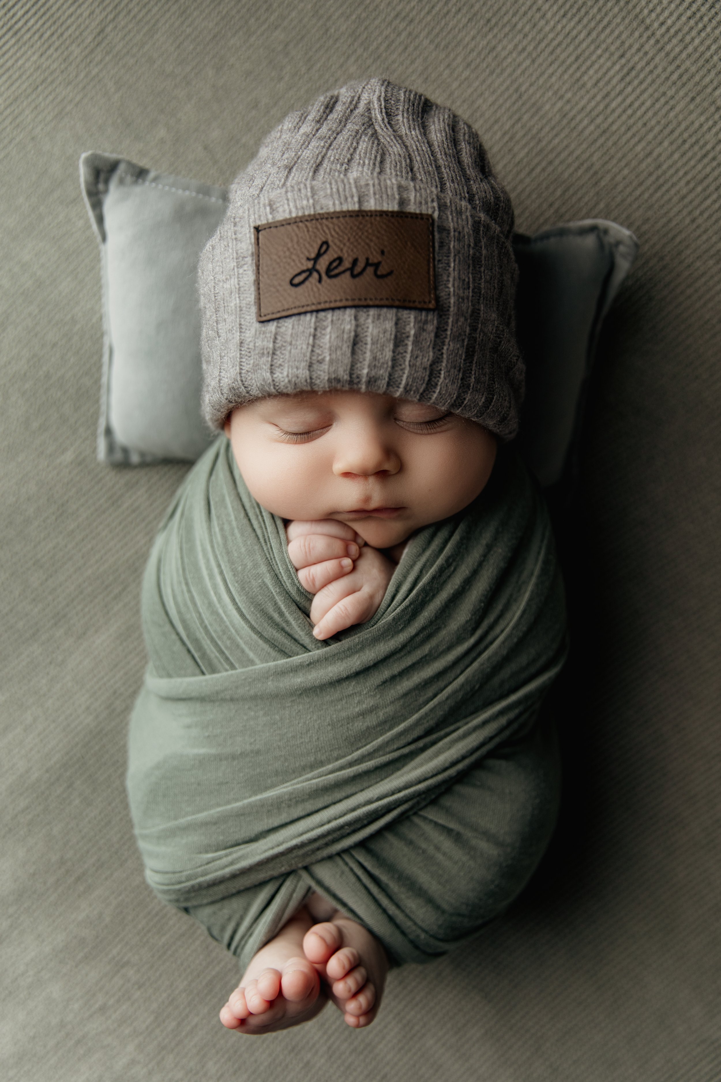 newborn_boy_wrapped_in_green_sleeps_on_pillow.jpg.jpg