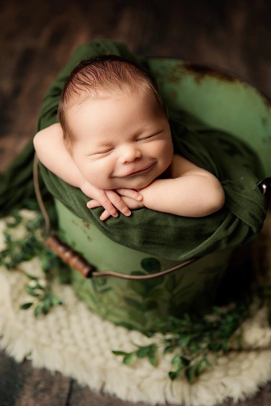 baby_boy_smiles_while_asleep_in_bucket