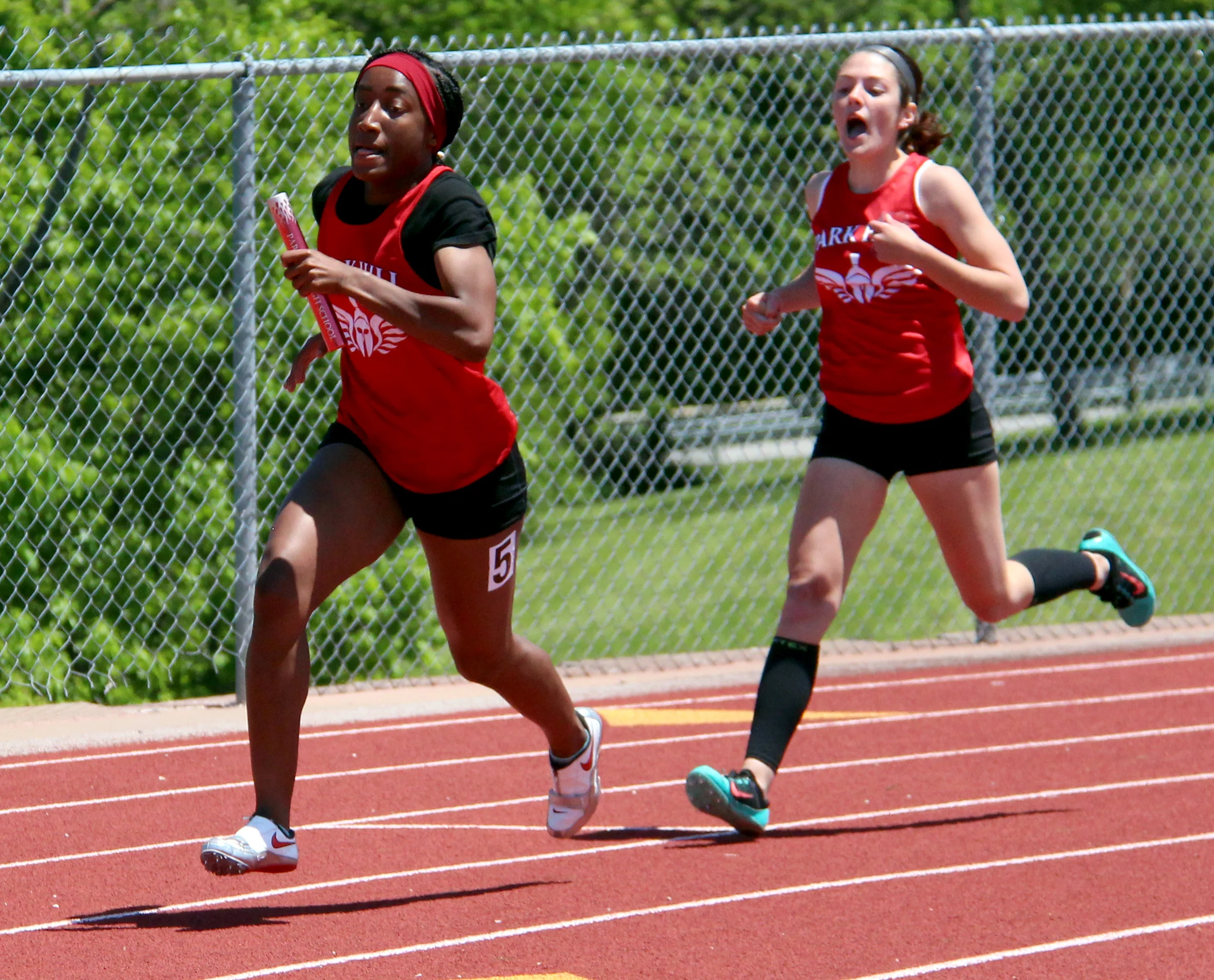 ROSS MARTIN/Citizen photo Park Hill’s Sephora Koudou, left, takes a handoff from Jena Hahlbeck during the 4x200 relay.