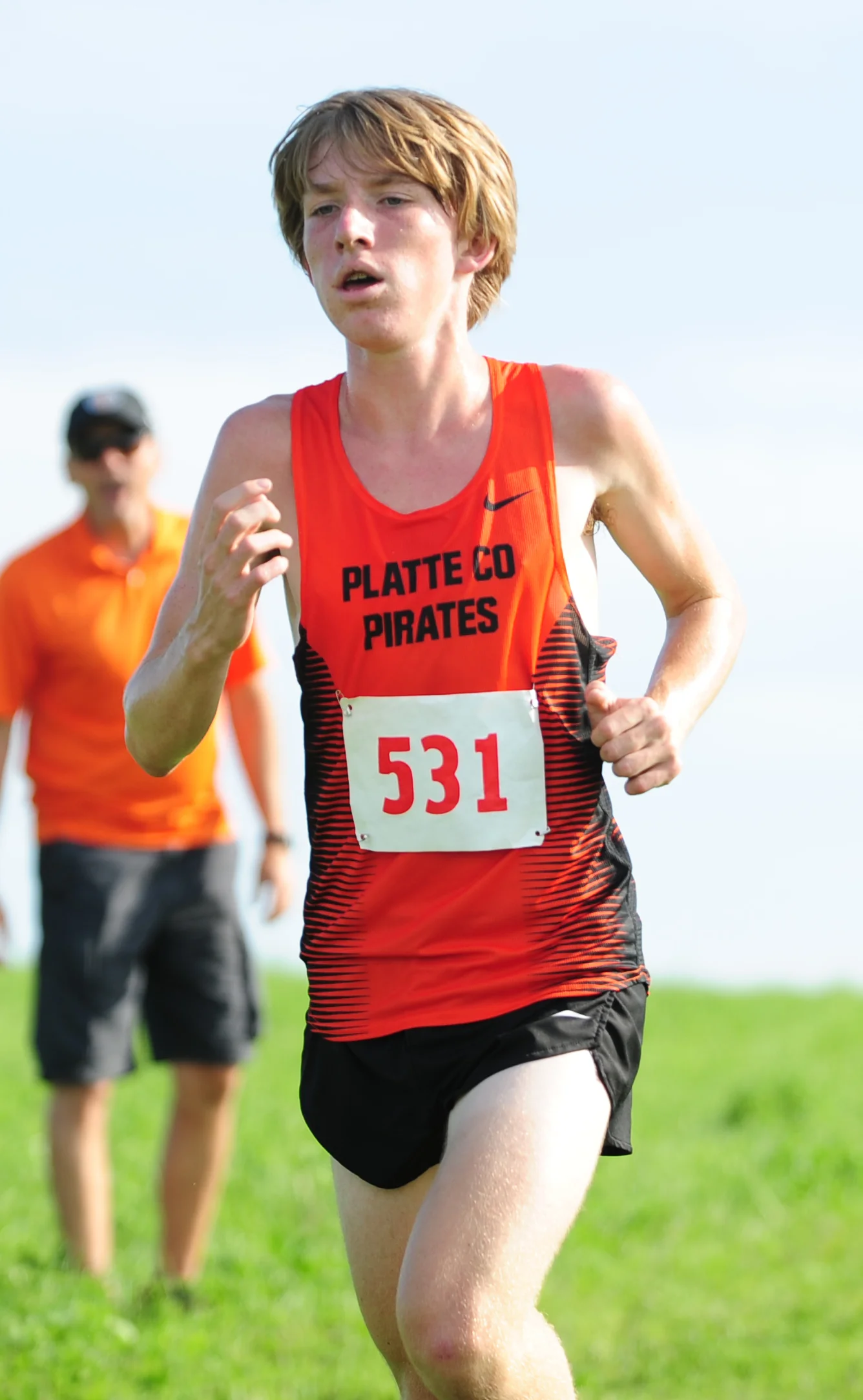 NICK INGRAM/Citizen photo Platte County sophomore Jackson Letcher hears words of encouragement from Pirates coach Chris Stubbs (rear) during the Platte County Invitational on Thursday, Sept. 15 at Platte Ridge Park.