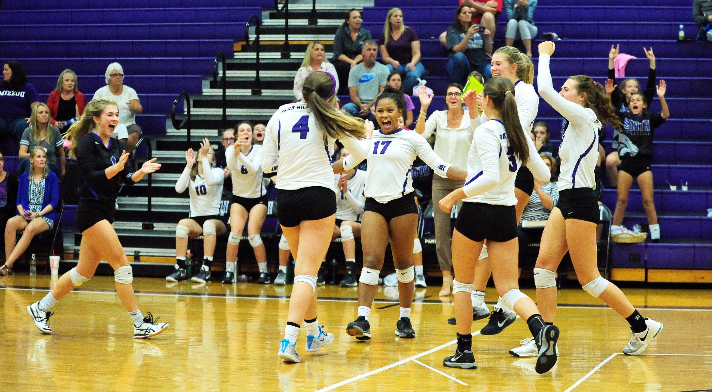 NICK INGRAM/Citizen photo Park Hill South players, including Kacy Lewallen (17) celebrate a point, in the matchup with Blue Springs.