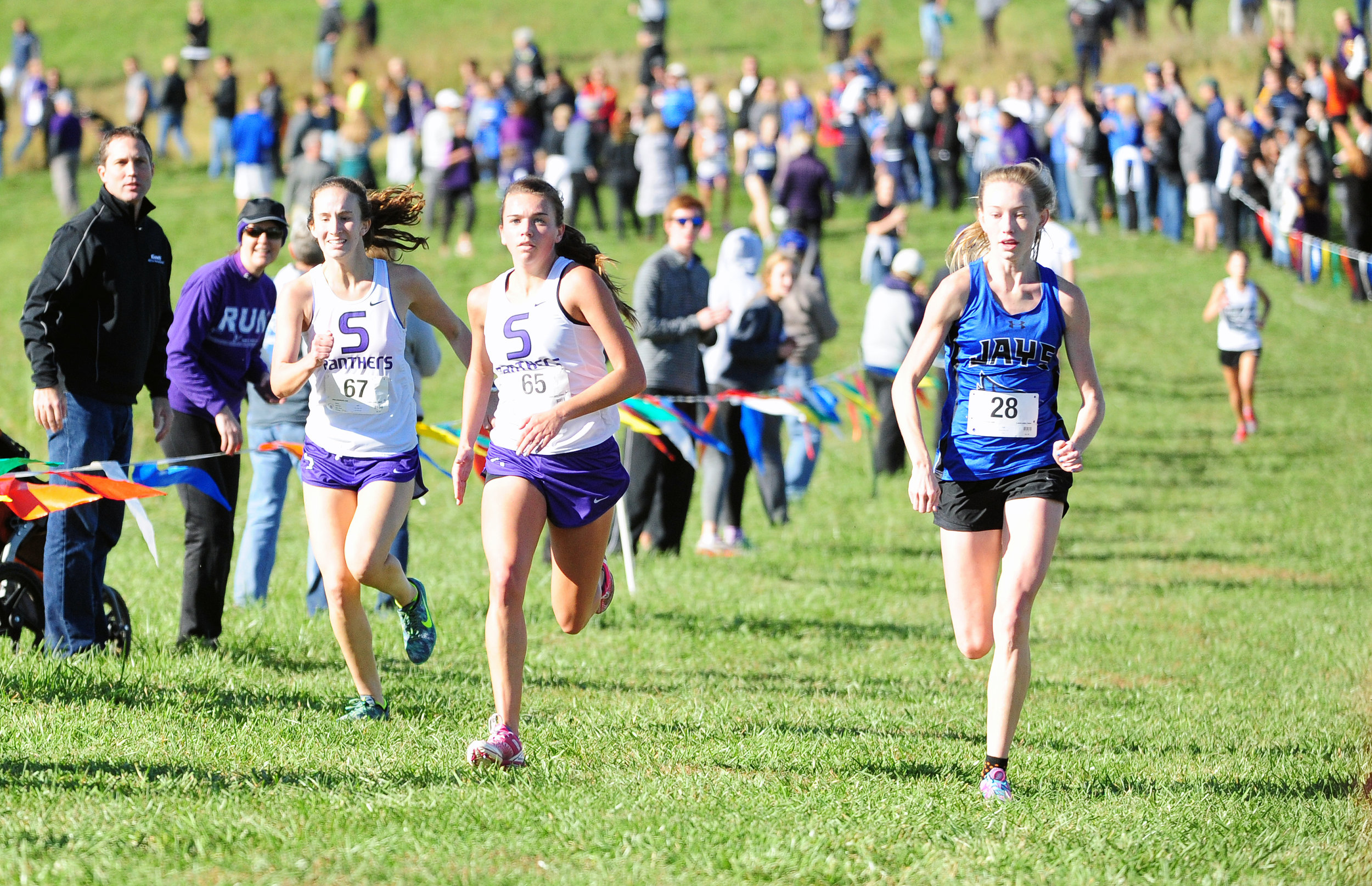 NICK INGRAM/Citizen photo Park Hill South’s Marti Heit, left, and Jasmine Crawford, center, run toward the finish line of the Class 4 District 8 race Saturday, Oct. 22 at Platte Ridge Park just outside of Platte City.