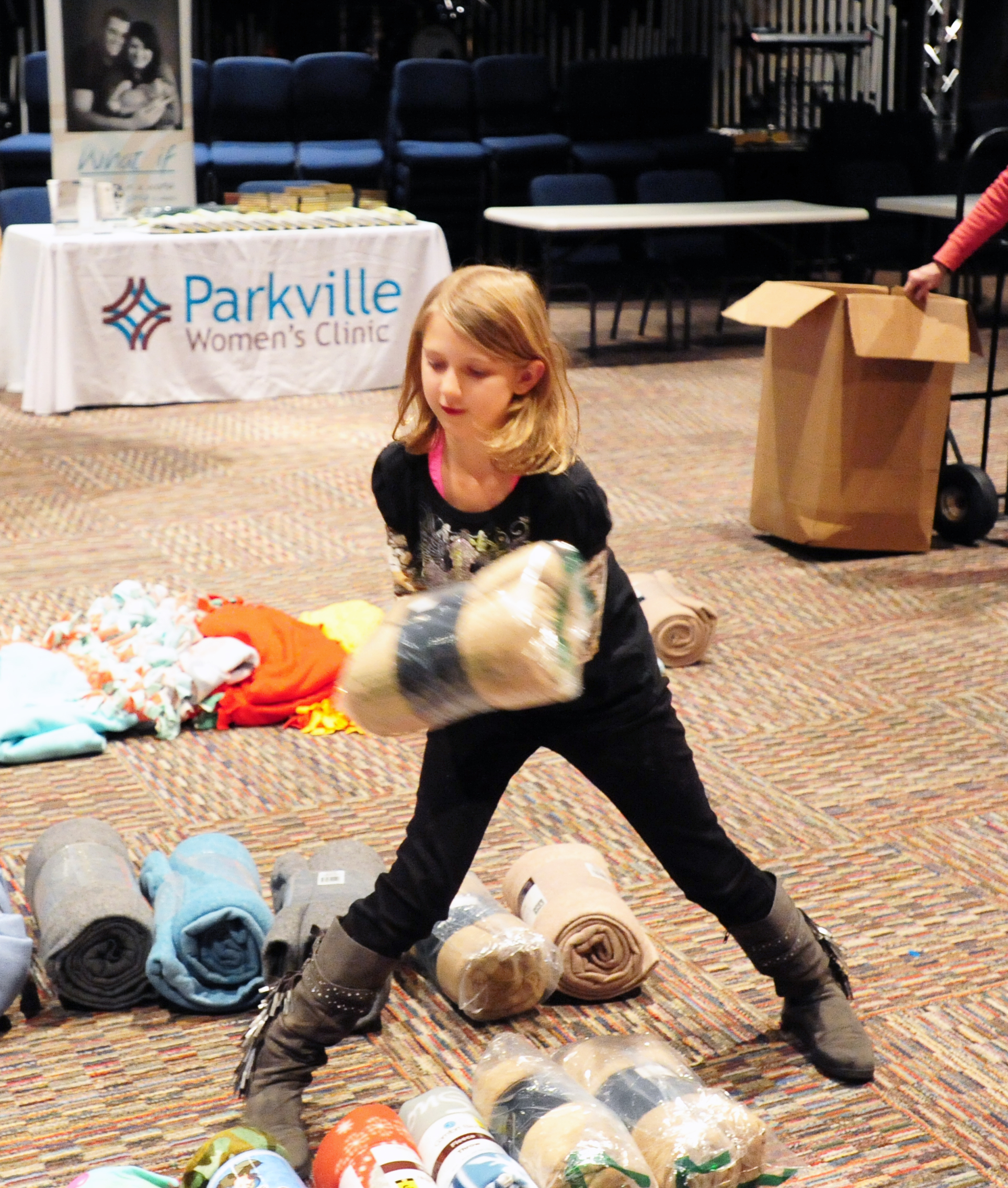 NICK INGRAM/Citizen photo Victoria Robinson, 9, sorts out the blankets she collected for the annual Day of Hope event held Saturday, Dec. 3 at the Rock of KC Church in Kansas, City, Mo. 