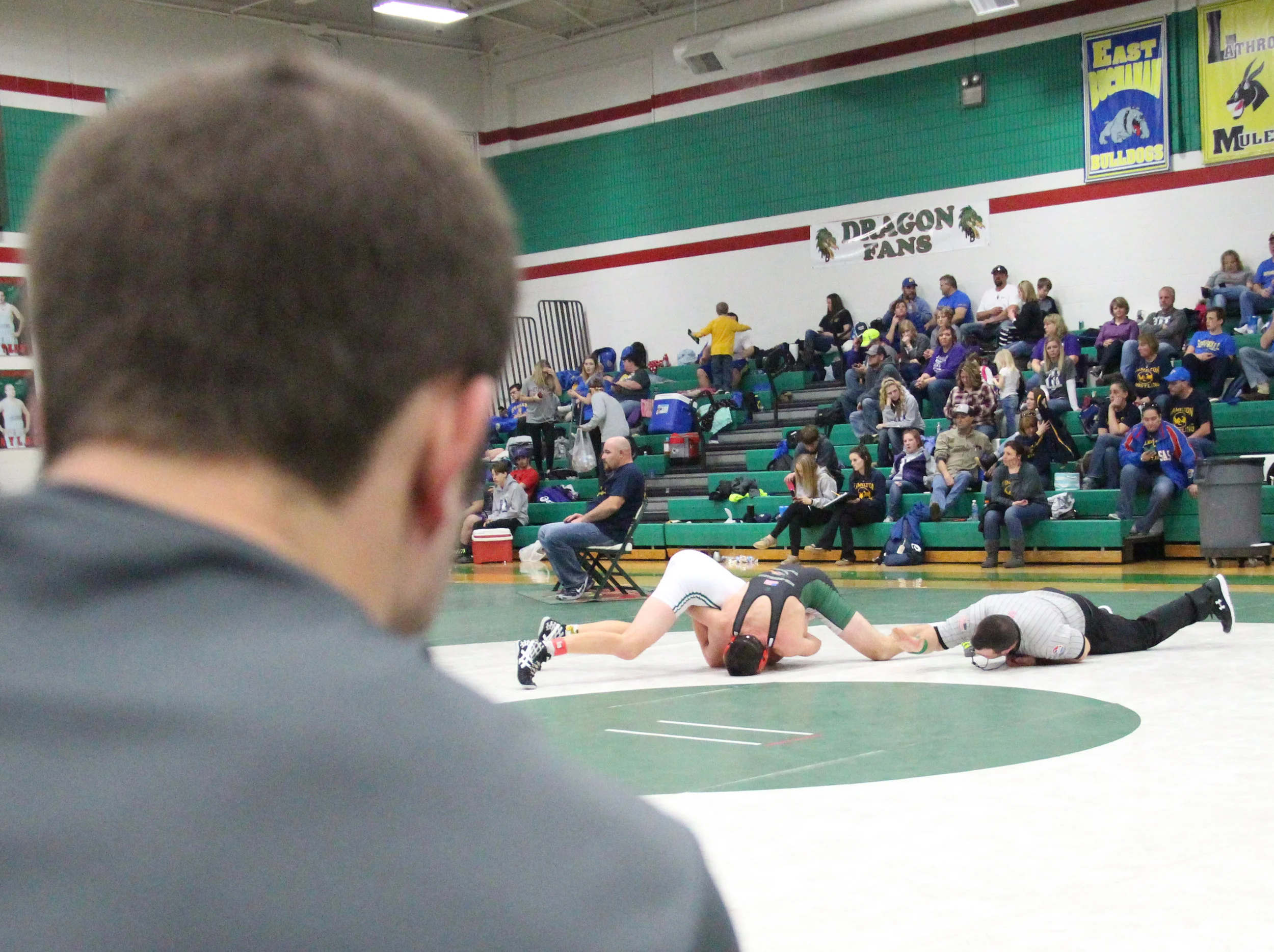 ROSS MARTIN/Citizen photo Mid-Buchanan assistant coach Jake Rumpf, front, looks on as Rotterman pins Maryville’s Jackson Sanders in the 160 championship match.