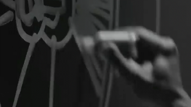 A person using a spray bottle to apply a cleaning solution to a surface with a distinctive geometric pattern.