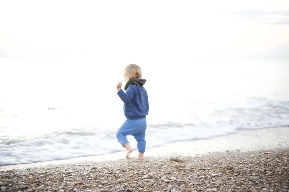 rowan picking stones running beach.jpg