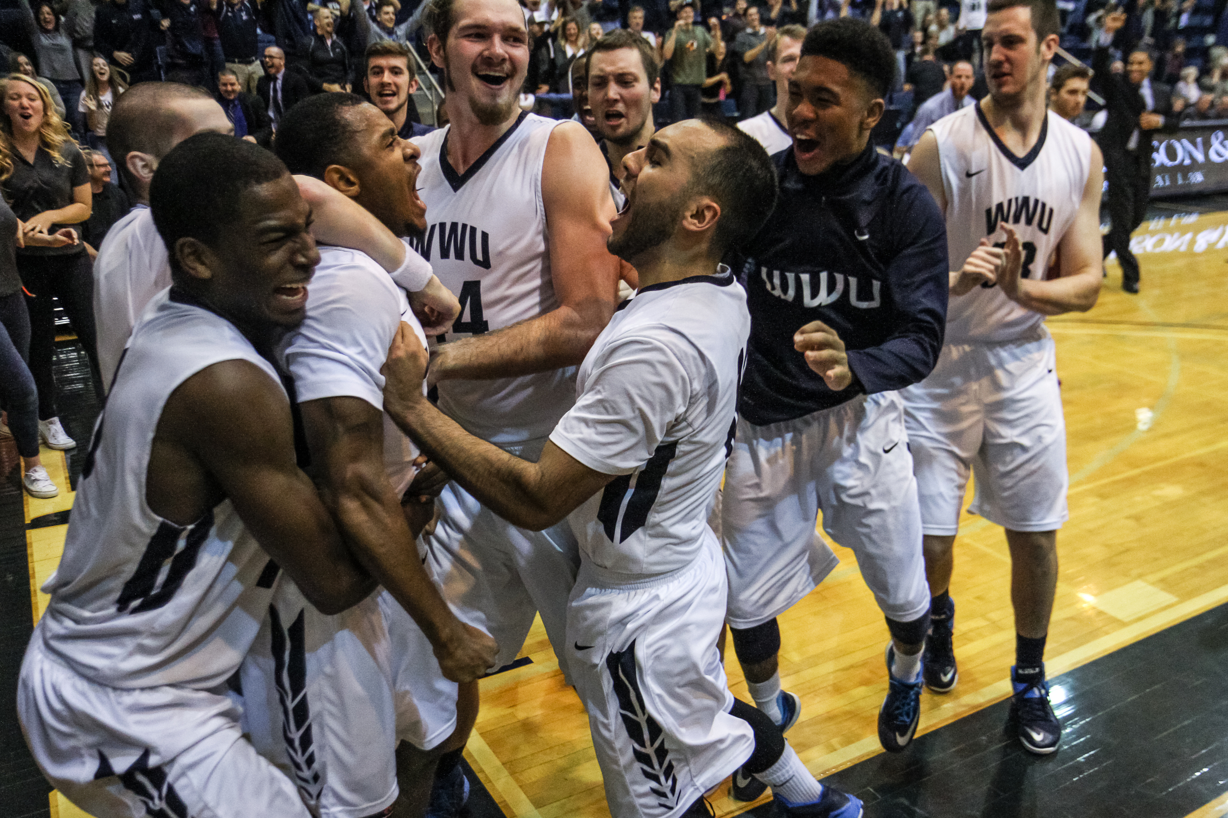 Western men's basketball players celebrate after winning with a last minute layup at the buzzer. Western fans stormed the court seconds later to celebrate with the team.