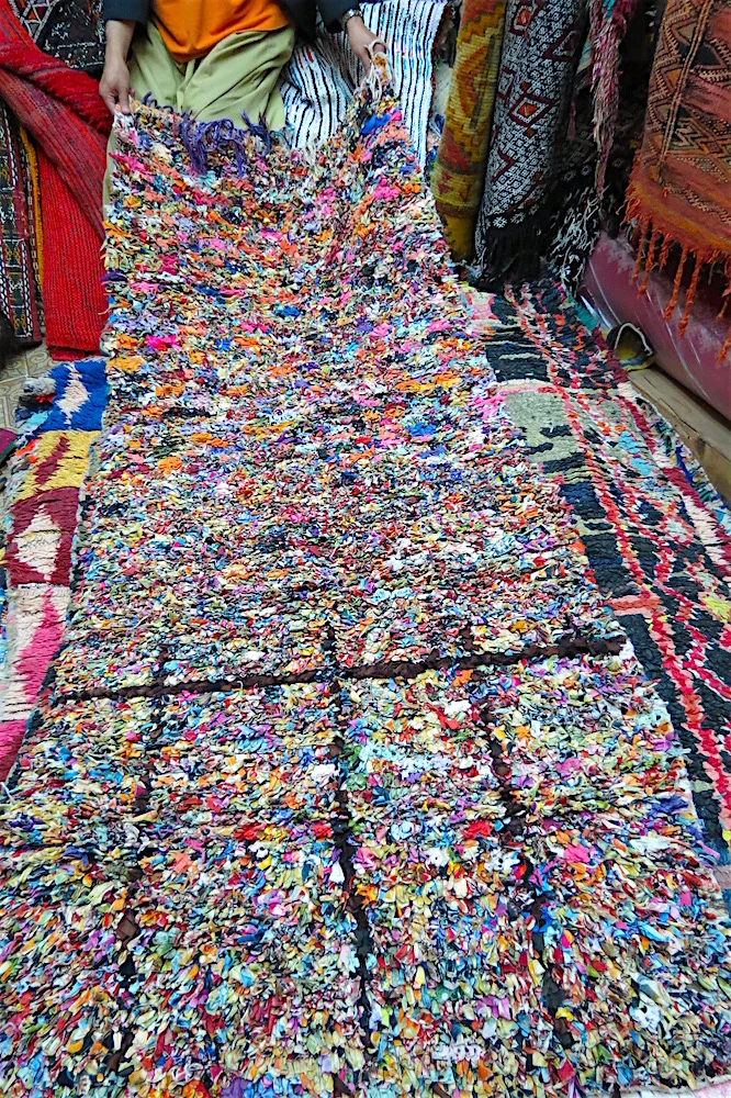 Unfurling a Boucherrette carpet made from rags in the Atlas Mountains