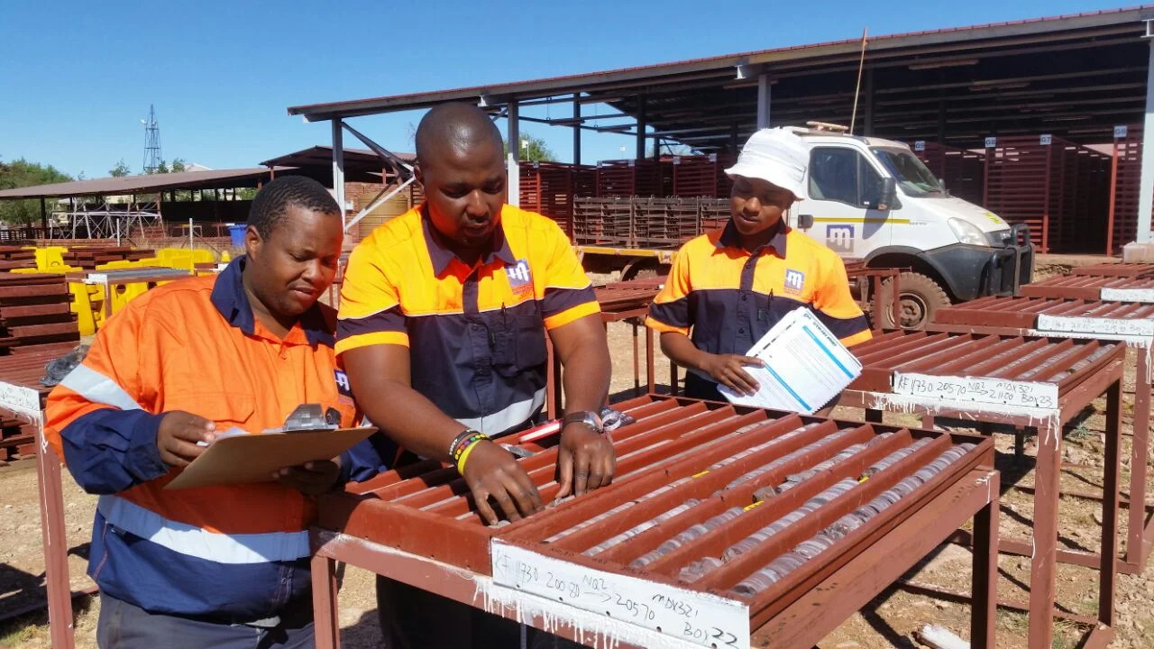 Trained Master Drilling scribes check the quality of core with Master Drilling geologist Mlamleli Chopela.