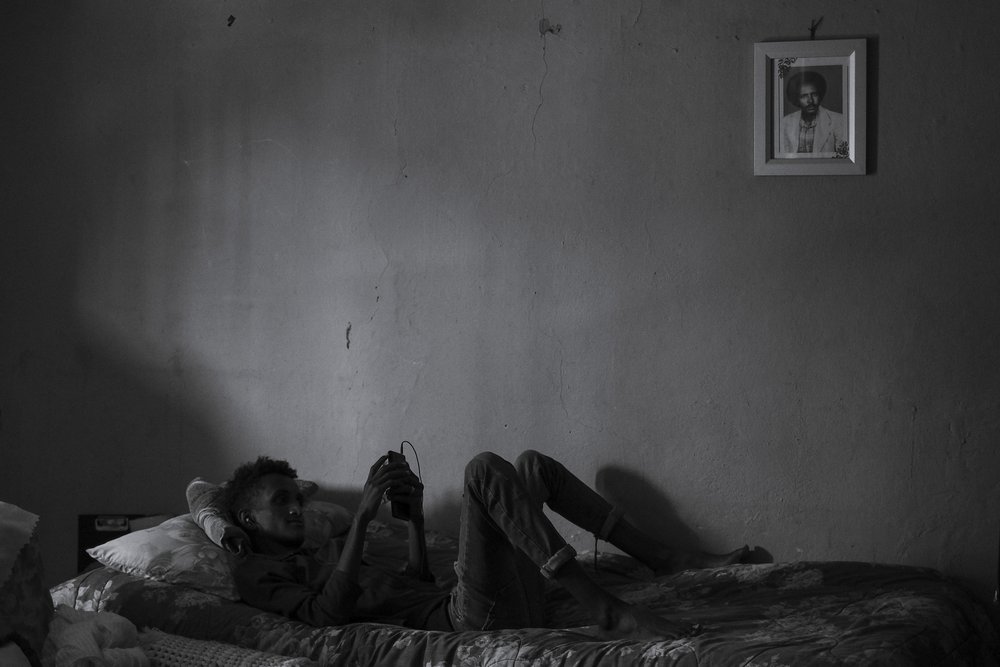 My nephew staring at his phone, home, Addis Ababa. From Eye of the Storm, 2021
