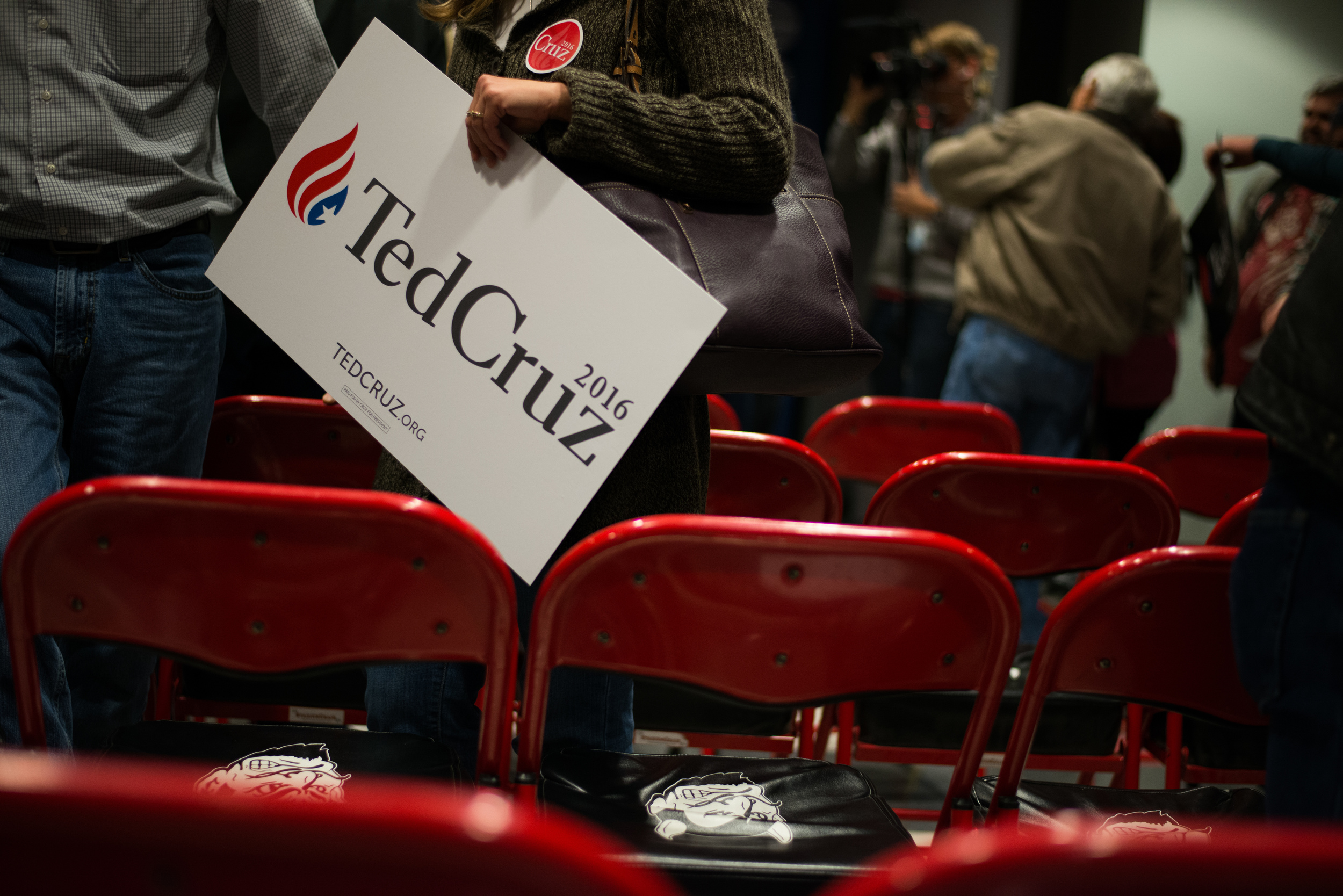  A woman carries a Ted Cruz campaign sign after Cruz addressed voters at Lamoni High School in Lamoni, Iowa, on Nov. 28, 2015. 
