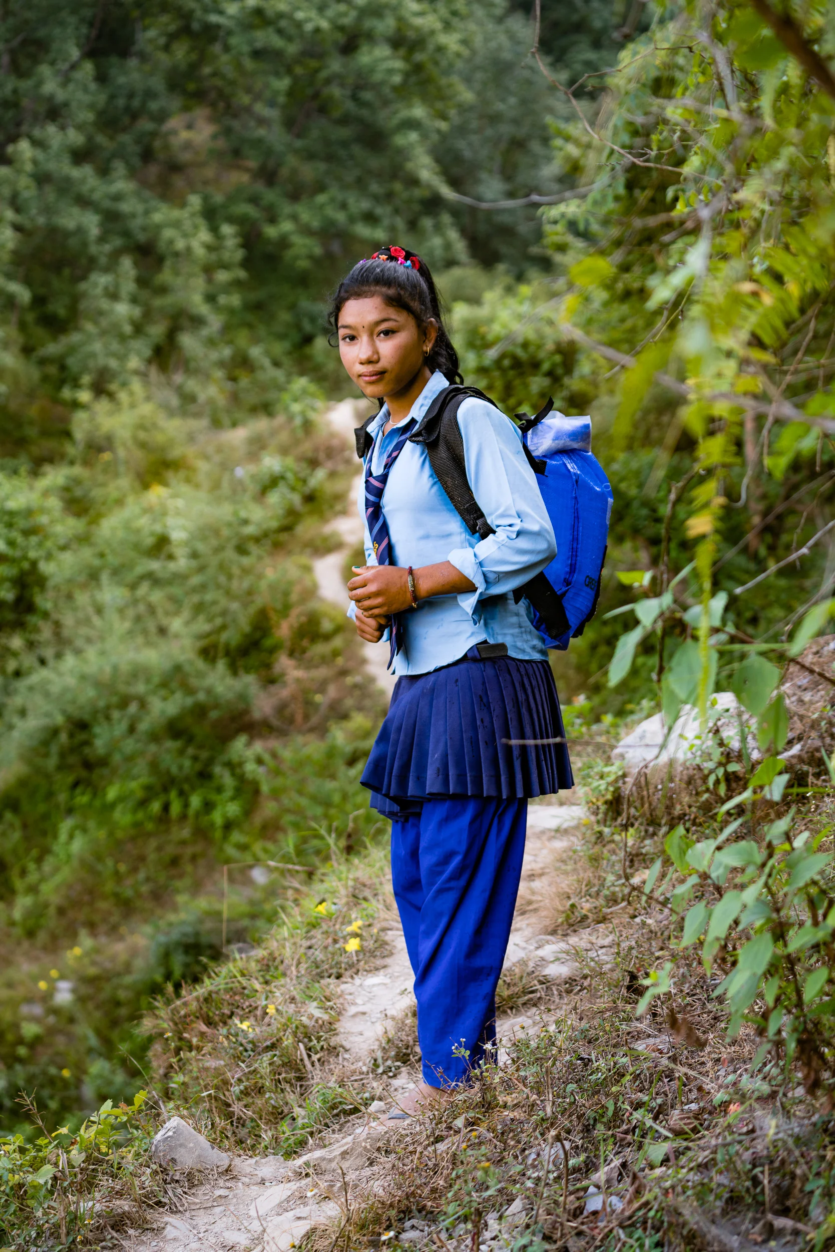 In small villages up in the mountains, one of the chores girls do is fetch water from a mountain spring. It is along a small, steep path cut into the mountainside. Literally hundreds of feet up. These backpacks designed to carry water provided by Kids of Kathmandu make the chore easier and safer.