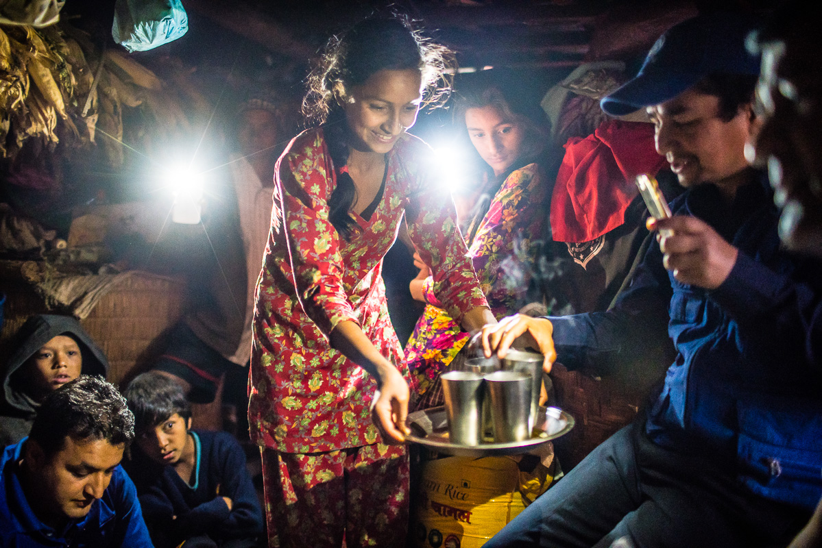 Crowded in the home staying dry while tea is passed around with iphones lighting the way.