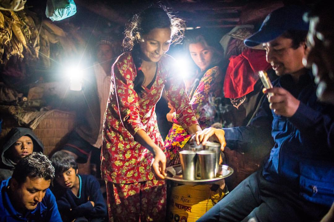 One of my favorite images from 2016. It was from an assignment for @Americares. We crowded into Junkiri's tiny one room home in the mountains of Sindhupalchok to escape the pouring rain. It was literally pitch black inside, so dark that I didn't notice that right next to me there was "grandfather" who put his hand on my arm to guide me to a seat. I suspect that Nepalis can see in the dark. As I was having a conversation in the darkness. I contemplated how I was going to be able to photograph. Then someone turned the light on their phone, then another, and another. It was beautiful, and a solution to my dilemma. Jinkiri's daughter went around offering us, and what looked like half the village crammed into her hut some tea and freshly made popcorn made from the corn she had drying in her home. It was a beautiful moment, and after some arranging of the "lights" I was able to get a good representation of that moment. We should have stayed over that night. The drive back down the mountain was a nightmare of roads blocked by parts of homes and power lines brought down by the storm.