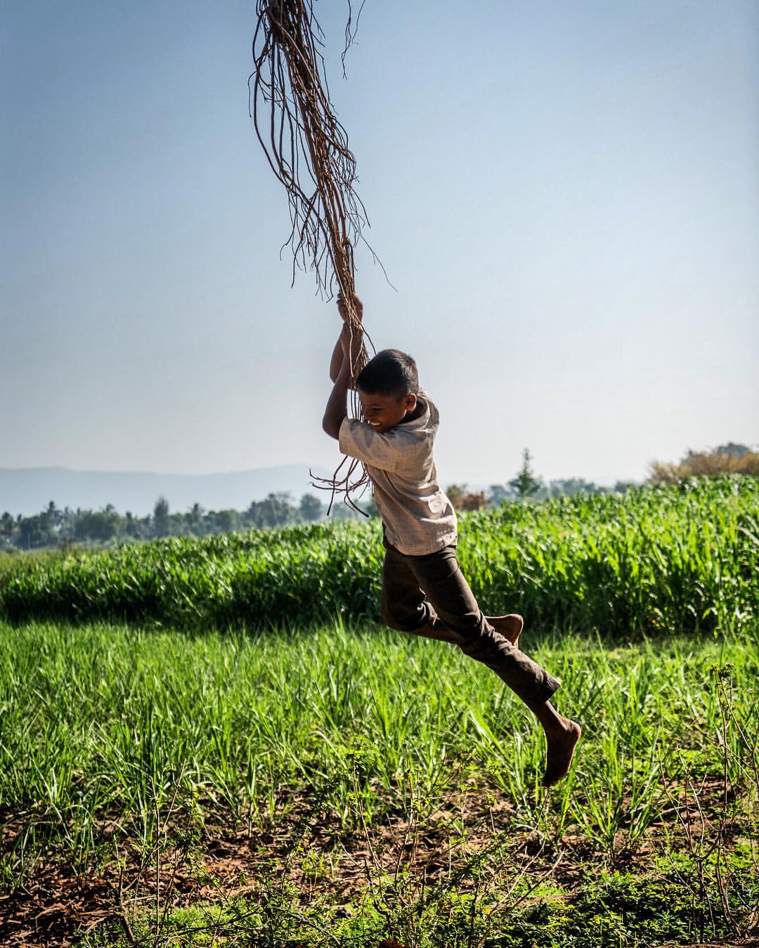On our way to the days location in rural India, and I spot out of the corner of my eye movement. I look and see off in the distance kids swinging from the hanging vines of a banyan tree. I of course make everyone go out of their way to go investigate. It was amazing and of course all the kids I happened to be photographing were there. Almost like I had planned it. Perfect! On assignment for Abbott .